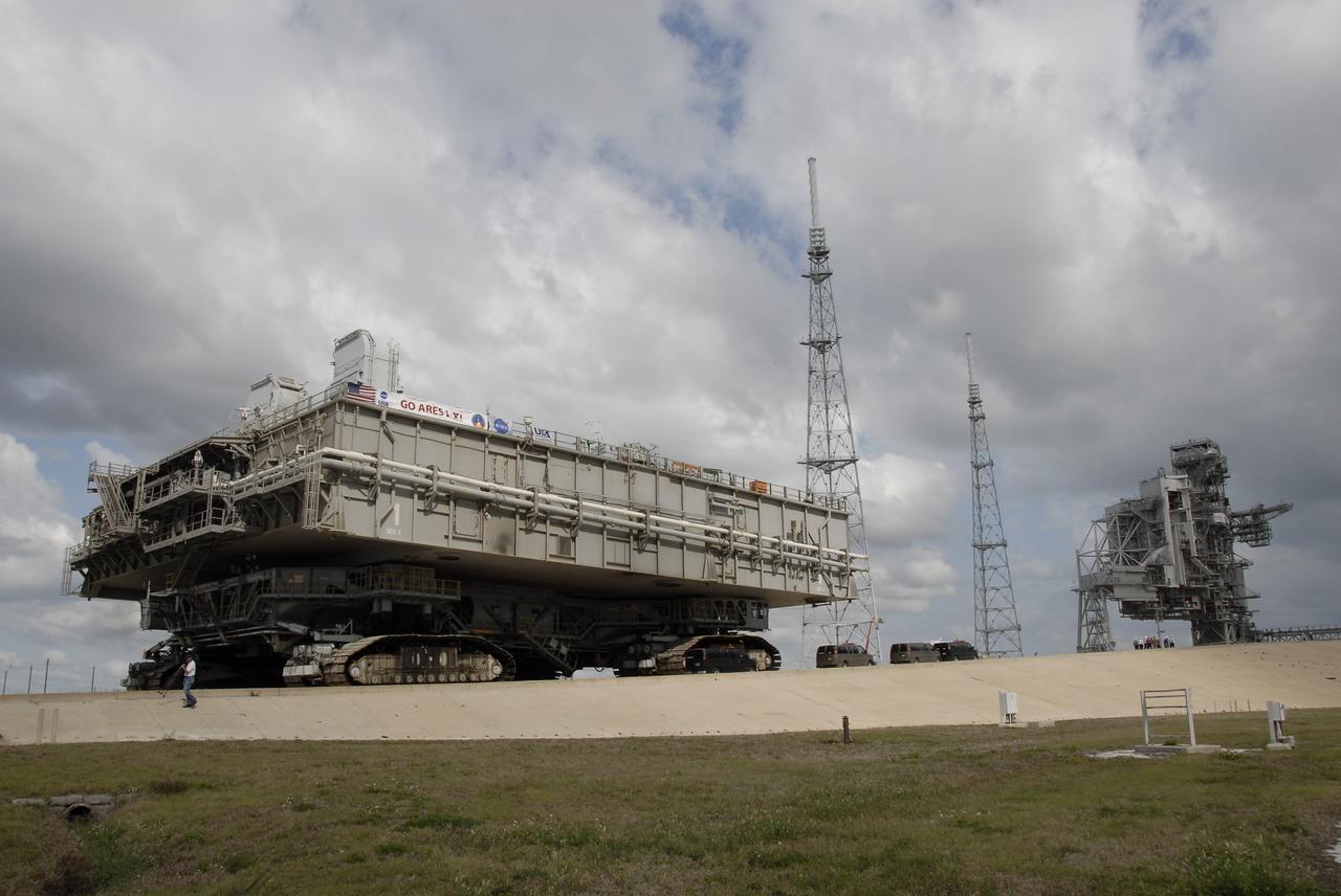 CAPE CANAVERAL, Fla. – Mobile Launcher Platform-1 is moving to Launch Pad 39B at NASA's Kennedy Space Center in Florida via the crawler-transporter underneath.  The MLP has been handed over to the Constellation Program for its future use for the Ares I-X flight test in the summer of 2009. Seen around the service structures on the pad are the new 600-foot lightning towers and masts erected for the Ares launches.  Ares I-X is the test vehicle for the Ares I, which is part of the Constellation Program to return men to the moon and beyond.  Ground Control System hardware was installed in MLP-1 in December 2008.  The MLP is being moved to the launch pad to check out the installed hardware with the Launch Control Center Firing Room 1 equipment, using the actual circuits that will be used when the fully stacked Ares I-X vehicle is rolled out later this year for launch. Following this testing, MLP-1 will be moved to the Vehicle Assembly Building's High Bay 3 to begin stacking, or assembling, Ares I-X.  Photo credit: NASA/Kim Shiflett