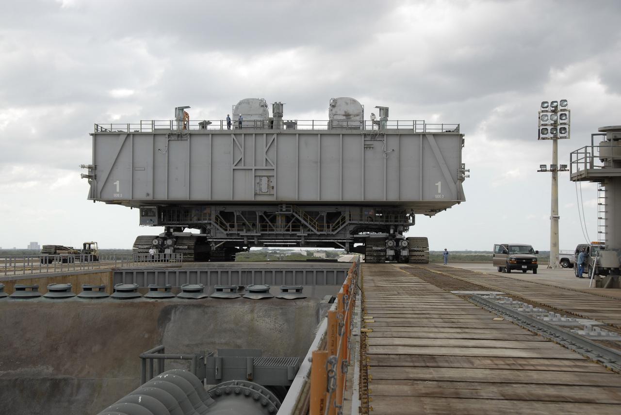 CAPE CANAVERAL, Fla. – Mobile Launcher Platform-1, on top of the crawler-transporter, nears the flame trench (lower left) on the top of Launch Pad 39B at NASA's Kennedy Space Center in Florida.  The MLP has been handed over to the Constellation Program for its future use for the Ares I-X flight test in the summer of 2009.  Ares I-X is the test vehicle for the Ares I, which is part of the Constellation Program to return men to the moon and beyond.  Ground Control System hardware was installed in MLP-1 in December 2008.  The MLP is being moved to the launch pad to check out the installed hardware with the Launch Control Center Firing Room 1 equipment, using the actual circuits that will be used when the fully stacked Ares I-X vehicle is rolled out later this year for launch. Following this testing, MLP-1 will be moved to the Vehicle Assembly Building's High Bay 3 to begin stacking, or assembling, Ares I-X.  Photo credit: NASA/Kim Shiflett