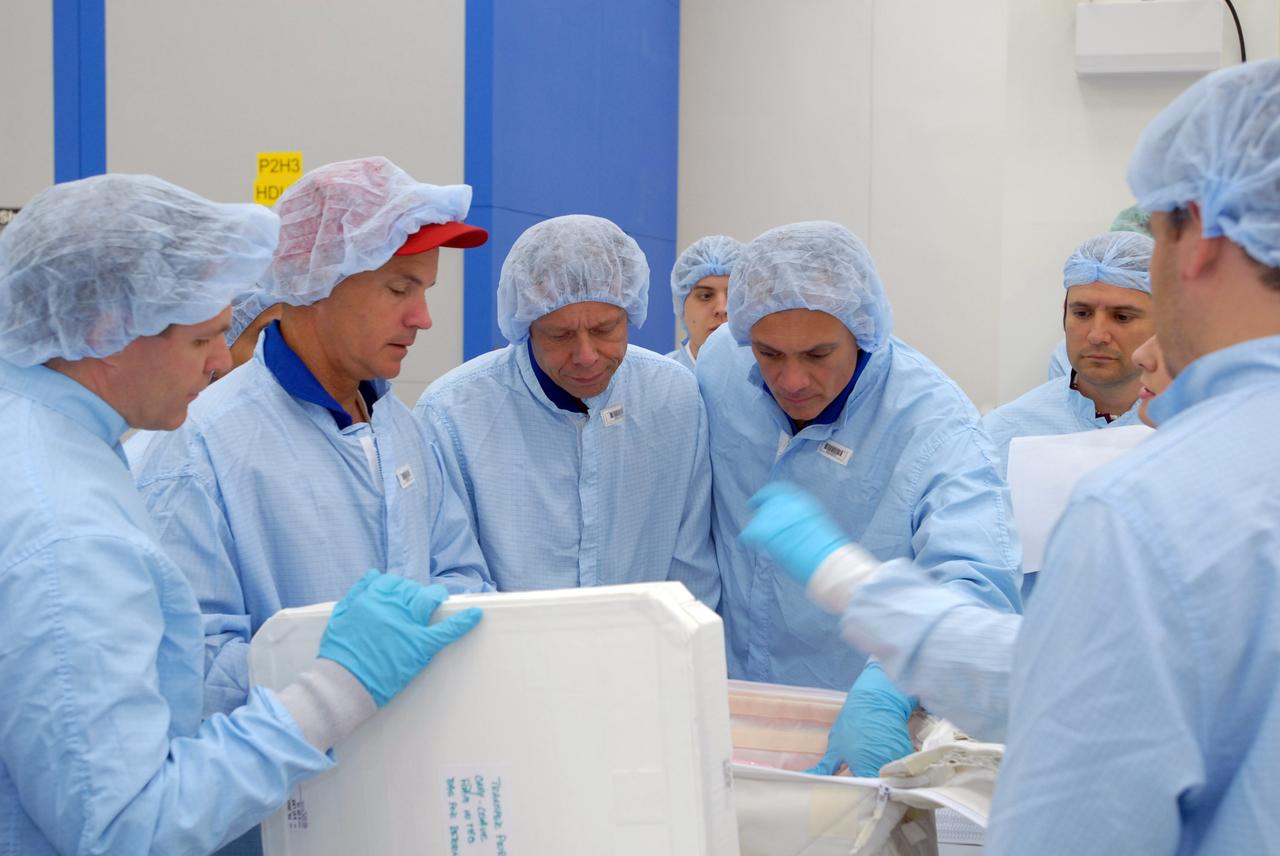 CAPE CANAVERAL, Fla. – In the Space Station Processing Facility, STS-128 crew members look over packages of equipment that will accompany the mission.  From left are Pilot Kevin Ford, Commander Rick Sturckow and Mission Specialists Christer Fuglesang and John "Danny" Olivas. The STS-128 flight will carry science and storage racks to the International Space Station on space shuttle Discovery. Launch of Discovery is targeted for Aug. 6.  Photo credit: NASA/Jim Grossmann
