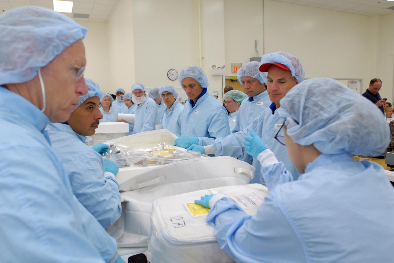 CAPE CANAVERAL, Fla. – In the Space Station Processing Facility, STS-128 crew members look over packages of equipment that will accompany the mission.   At left are Mission Specialists Patrick Forrester and Jose Hernandez.  At right are Commander Rick Sturckow (with the red cap) and on his left Mission Specialists Christer Fuglesang and John "Danny" Olivas.  The STS-128 flight will carry science and storage racks to the International Space Station on space shuttle Discovery. Launch of Discovery is targeted for Aug. 6.  Photo credit: NASA/Jim Grossmann