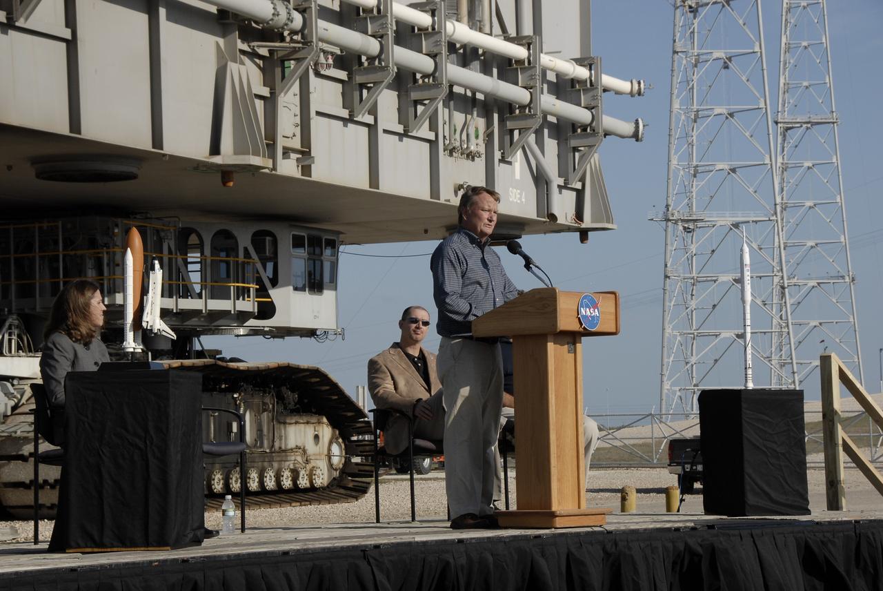 CAPE CANAVERAL, Fla. – Near Launch Pad 39B  at NASA's Kennedy Space Center in Florida, Shuttle Launch Director Mike Leinbach speaks to the employees and media during the handover ceremony for Mobile Launcher Platform-1. The platform is being transferred from NASA's Space Shuttle Program to the Constellation Program for the Ares I-X flight test targeted for this summer. Also participating in the ceremony are (left) Rita Willcoxon, director of Launch Vehicle Processing at Kennedy, (right) Pepper E. Phillips, director of the Constellation Project Office, and (not visible) Brett Raulerson, manager of MLP Operations with United Space Alliance. Constructed in 1964, the mobile launchers used in Apollo/Saturn operations were modified for use in shuttle operations. With cranes, umbilical towers and swing arms removed, the mobile launchers were renamed Mobile Launcher Platforms, or MLPs.  Photo credit: NASA/Kim Shiflett