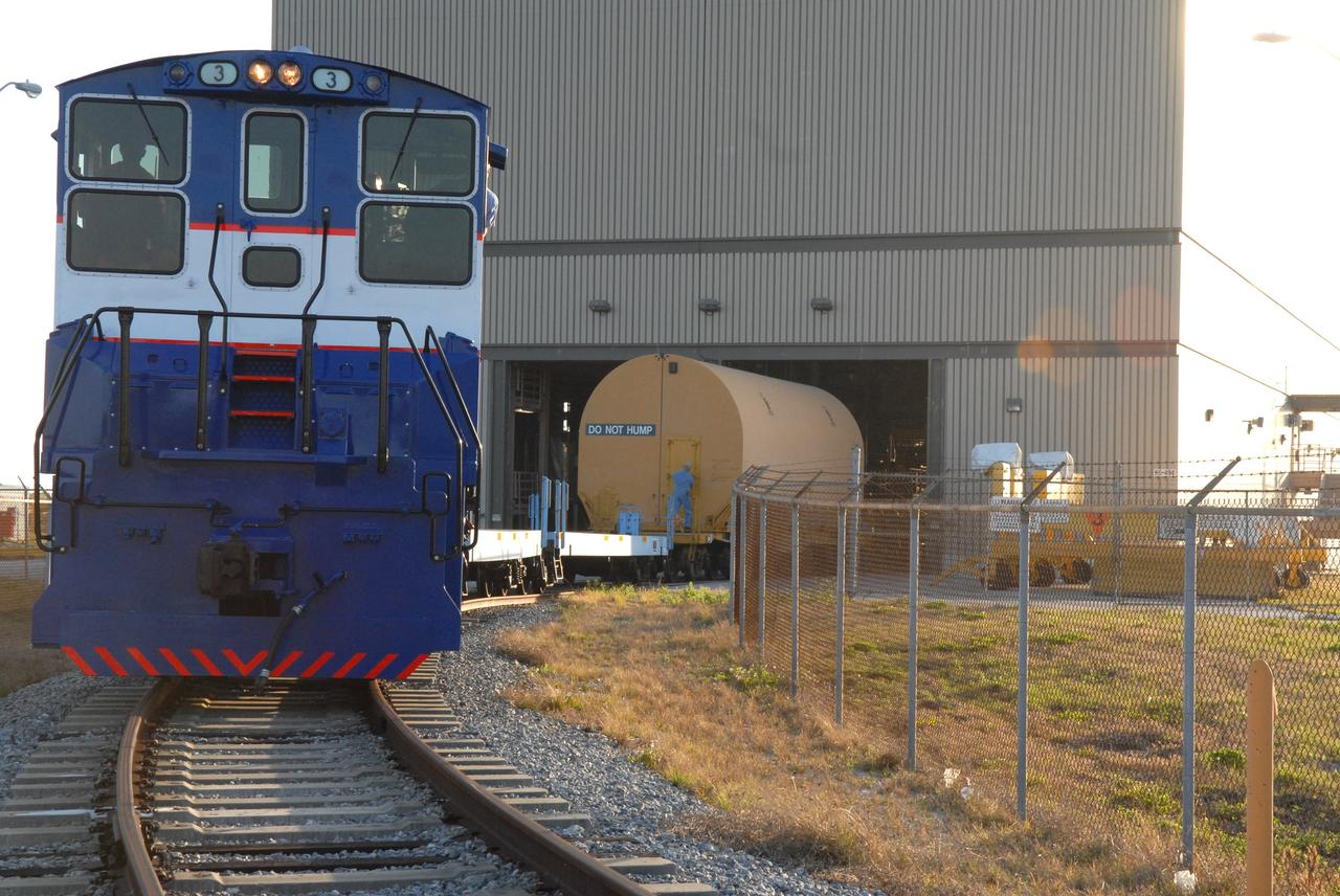 CAPE CANAVERAL, Fla. – The NASA Railroad delivers the first Ares I-X segment to the Rotation, Processing and Surge Facility at NASA's Kennedy Space Center in Florida. Four reusable motor segments and the nozzle exit cone, manufactured by the Ares I first-stage prime contractor Alliant Techsystems Inc.,  departed Utah March 12 on the seven-day, cross-country trip to Florida.  The segments are being delivered to Kennedy's  Rotation, Processing and Surge Facility for final processing and integration. The booster used for the Ares I-X launch is being modified by adding new forward structures and a fifth segment simulator. The motor is the final hardware needed for the rocket's upcoming test flight this summer. The stacking operations are scheduled to begin in the Vehicle Assembly Building in April.  Photo credit: NASA/Jack Pfaller