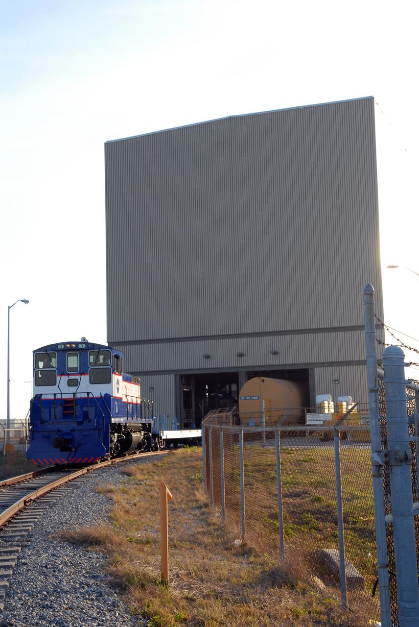CAPE CANAVERAL, Fla. – The NASA Railroad delivers the first Ares I-X segment to the Rotation, Processing and Surge Facility at NASA's Kennedy Space Center in Florida. Four reusable motor segments and the nozzle exit cone, manufactured by the Ares I first-stage prime contractor Alliant Techsystems Inc.,  departed Utah March 12 on the seven-day, cross-country trip to Florida.  The segments are being delivered to Kennedy's  Rotation, Processing and Surge Facility for final processing and integration. The booster used for the Ares I-X launch is being modified by adding new forward structures and a fifth segment simulator. The motor is the final hardware needed for the rocket's upcoming test flight this summer. The stacking operations are scheduled to begin in the Vehicle Assembly Building in April.  Photo credit: NASA/Jack Pfaller