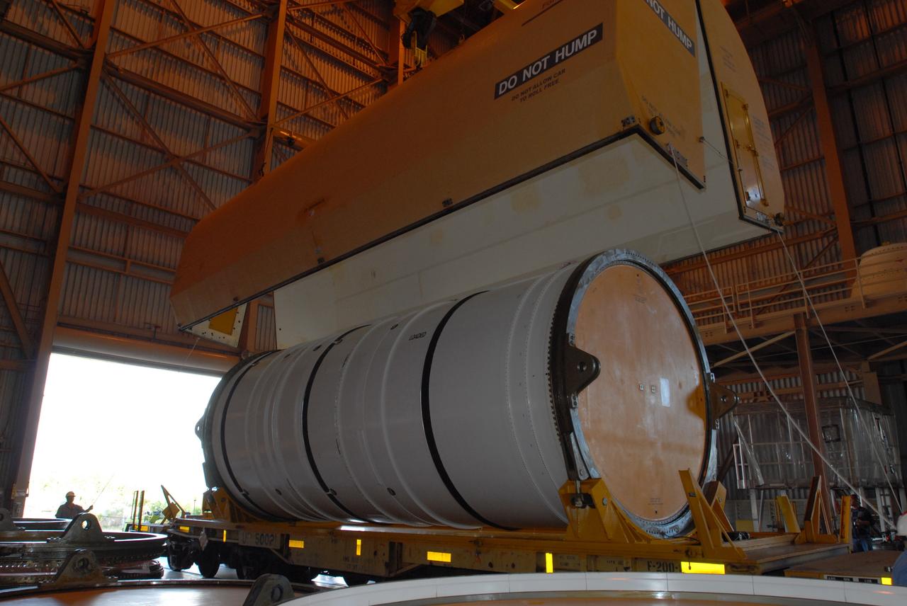 CAPE CANAVERAL, Fla. – In the Rotation, Processing and Surge Facility at NASA's Kennedy Space Center in Florida, the rail car cover is removed from the first Ares I-X motor segment.  It is one of four reusable motor segments and nozzle exit cone shipped by the Ares I first-stage prime contractor Alliant Techsystems Inc. for final processing and integration in the facility. The booster used for the Ares I-X launch is being modified by adding new forward structures and a fifth segment simulator. The motor is the final hardware needed for the rocket's upcoming flight test this summer. The stacking operations are scheduled to begin in the Vehicle Assembly Building in April. Photo credit: NASA/Jim Grossmann