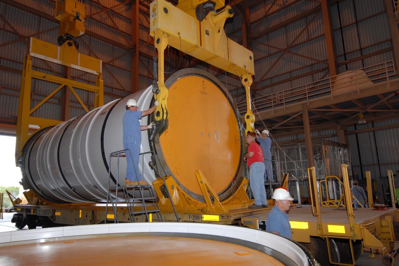 CAPE CANAVERAL, Fla. –  Technicians adjust the crane being attached to the first of the Ares I-X motor segments that will raise it for transfer it to a work stand in the Rotation, Processing and Surge Facility at NASA's Kennedy Space Center in Florida. Four segments were delivered to Kennedy for final processing and integration. The booster used for the Ares I-X launch is being modified by adding new forward structures and a fifth segment simulator. The motor is the final hardware needed for the rocket's upcoming test flight this summer. The stacking operations are scheduled to begin in the Vehicle Assembly Building in April.  Photo credit: NASA/Jack Pfaller