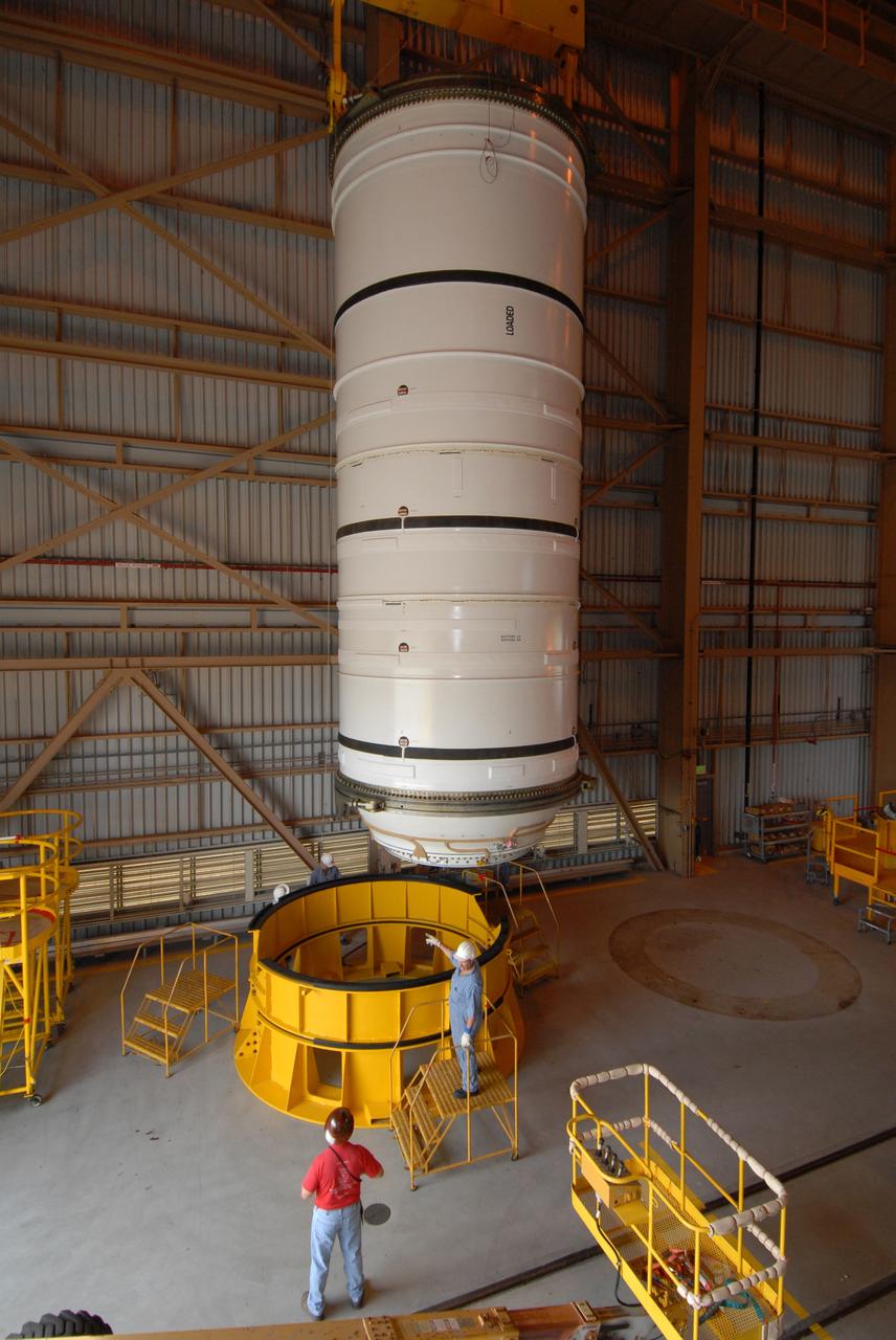 CAPE CANAVERAL, Fla. –  Under the watchful eyes of technicians, the Ares I-X motor segment is moved toward a work stand in the Rotation, Processing and Surge Facility at NASA's Kennedy Space Center in Florida. Four segments were delivered to Kennedy for final processing and integration. The booster used for the Ares I-X launch is being modified by adding new forward structures and a fifth segment simulator. The motor is the final hardware needed for the rocket's upcoming test flight this summer. The stacking operations are scheduled to begin in the Vehicle Assembly Building in April.  Photo credit: NASA/Jack Pfaller