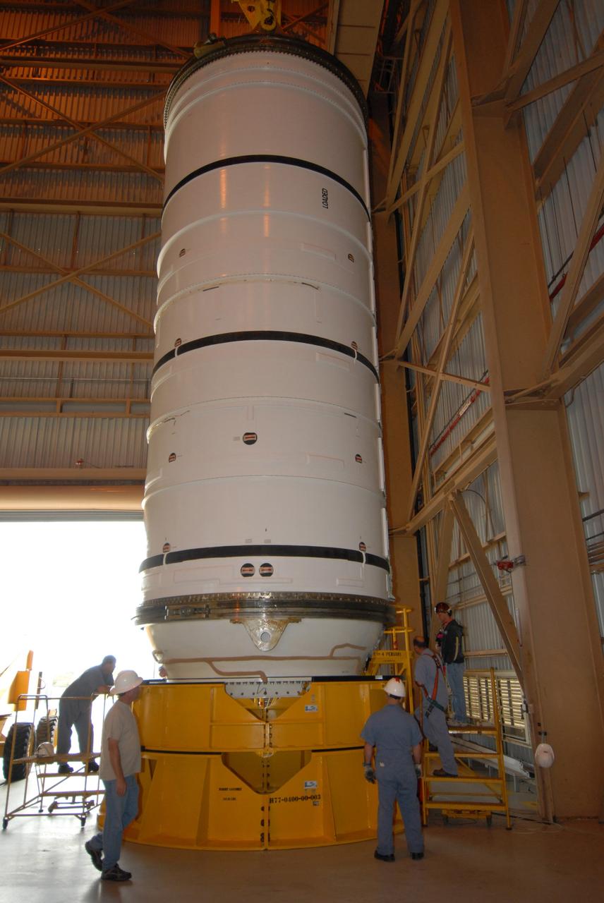 CAPE CANAVERAL, Fla. –  The Ares I-X motor segment is lowered onto a work stand in the Rotation, Processing and Surge Facility at NASA's Kennedy Space Center in Florida.  Four segments were delivered to Kennedy for final processing and integration. The booster used for the Ares I-X launch is being modified by adding new forward structures and a fifth segment simulator. The motor is the final hardware needed for the rocket's upcoming test flight this summer. The stacking operations are scheduled to begin in the Vehicle Assembly Building in April.  Photo credit: NASA/Jack Pfaller