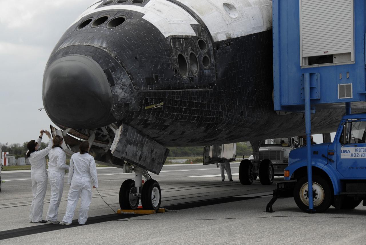 CAPE CANAVERAL, Fla. – Workers inspect space shuttle Discovery following touchdown on Runway 15 at NASA's Kennedy Space Center in Florida to complete the 13-day, 5.3-million mile journey on the STS-119 mission to the International Space Station. Main gear touchdown was at 3:13:17 p.m. EDT.  Nose gear touchdown was at 3:13:40 p.m. and wheels stop was at 3:14:45 p.m.  Discovery delivered the final pair of large power-generating solar array wings and the S6 truss segment. The mission was the 28th flight to the station, the 36th flight of Discovery and the 125th in the Space Shuttle Program, as well as the 70th landing at Kennedy. Photo credit: NASA/Kim Shiflett