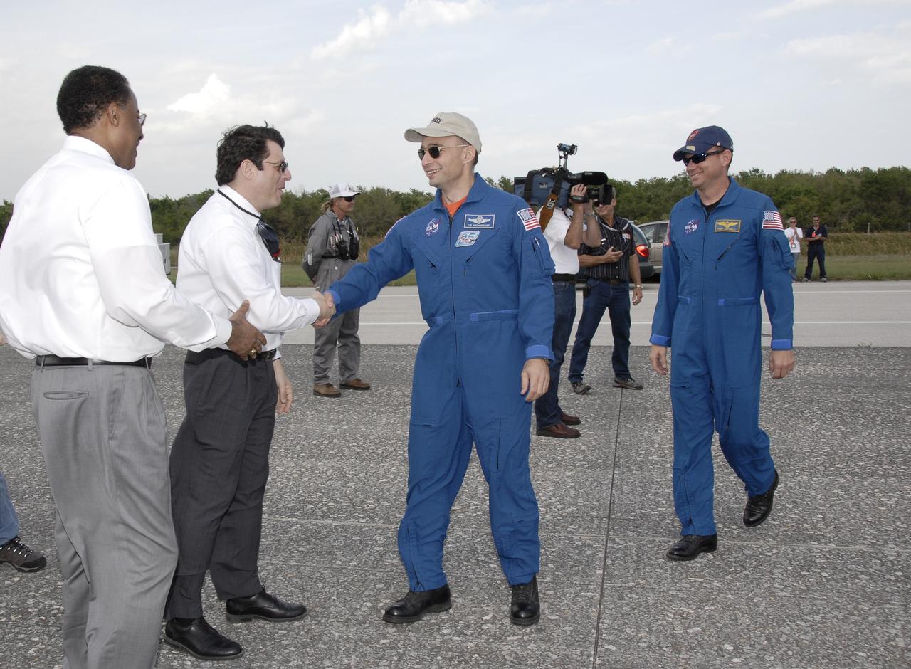 CAPE CANAVERAL, Fla. – STS-119 Commander Lee Archambault shakes hands with NASA Acting Administrator Chris Scolese as NASA Deputy Associate Administrator Charles Scales, left, also prepares to welcome him home.  Pilot Tony Antonelli approaches the group, at right. Space shuttle Discovery’s landing completed the 13-day, 5.3-million mile journey of the STS-119 mission to the International Space Station.  Main gear touchdown was at 3:13:17 p.m. EDT.  Nose gear touchdown was at 3:13:40 p.m. and wheels stop was at 3:14:45 p.m.  Discovery delivered the final pair of large power-generating solar array wings and the S6 truss segment. The mission was the 28th flight to the station, the 36th flight of Discovery and the 125th in the Space Shuttle Program, as well as the 70th landing at Kennedy. Photo credit: NASA/Kim Shiflett