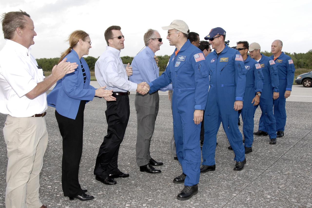 CAPE CANAVERAL, Fla. – STS-119 Commander Lee Archambault shakes hands with NASA Deputy Manager of Space Shuttle Program LeRoy Cain (third from left) as Pilot Tony Antonelli, behind him, is greeted by NASA Associate Administrator for Space Operations Bill Gerstenmaier.  Shuttle Launch Director Mike Leinbach, left, and Kennedy Space Center Deputy Director Janet Petro also await their turns to welcome the crew home.  Space shuttle Discovery’s landing completed the 13-day, 5.3-million mile journey of the STS-119 mission to the International Space Station.  Main gear touchdown was at 3:13:17 p.m. EDT.  Nose gear touchdown was at 3:13:40 p.m. and wheels stop was at 3:14:45 p.m.  Discovery delivered the final pair of large power-generating solar array wings and the S6 truss segment. The mission was the 28th flight to the station, the 36th flight of Discovery and the 125th in the Space Shuttle Program, as well as the 70th landing at Kennedy. Photo credit: NASA/Kim Shiflett