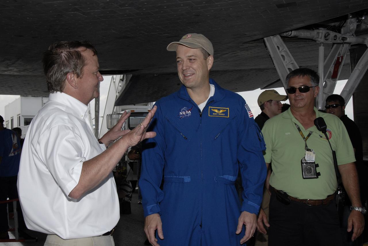 CAPE CANAVERAL, Fla. – Shuttle Launch Director Mike Leinbach, left, talks with STS-119 Mission Specialist Richard Arnold beneath space shuttle Discovery on Runway 15 at NASA's Kennedy Space Center in Florida. Discovery’s landing completed the 13-day, 5.3-million mile journey of the STS-119 mission to the International Space Station. Main gear touchdown was at 3:13:17 p.m. EDT. Nose gear touchdown was at 3:13:40 p.m. and wheels stop was at 3:14:45 p.m. Discovery delivered the final pair of large power-generating solar array wings and the S6 truss segment. The mission was the 28th flight to the station, the 36th flight of Discovery and the 125th in the Space Shuttle Program, as well as the 70th landing at Kennedy. Photo credit: NASA/Kim Shiflett