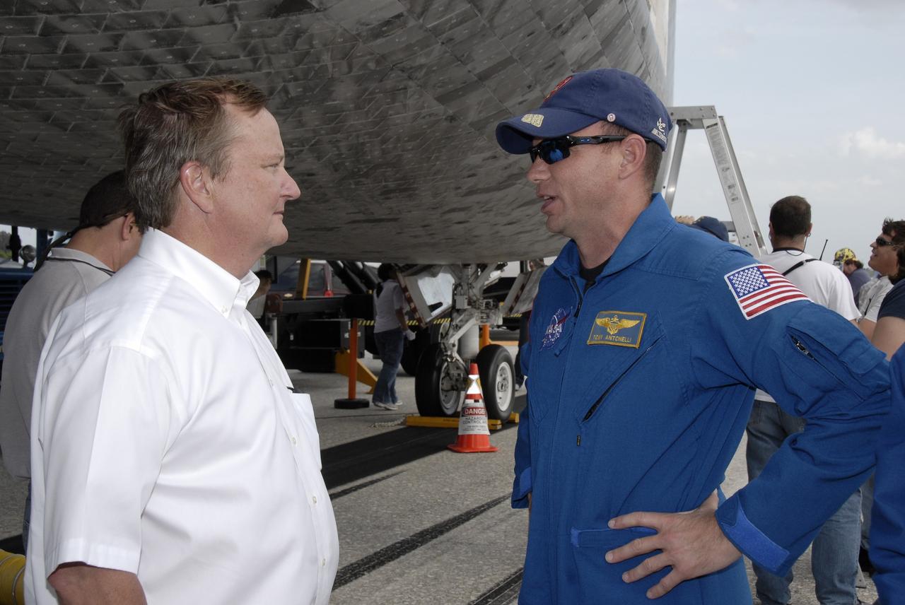 CAPE CANAVERAL, Fla. – Shuttle Launch Director Mike Leinbach, left, talks with STS-119 Pilot Tony Antonelli beneath space shuttle Discovery on Runway 15 at NASA's Kennedy Space Center in Florida. Discovery’s landing completed the 13-day, 5.3-million mile journey of the STS-119 mission to the International Space Station. Main gear touchdown was at 3:13:17 p.m. EDT. Nose gear touchdown was at 3:13:40 p.m. and wheels stop was at 3:14:45 p.m. Discovery delivered the final pair of large power-generating solar array wings and the S6 truss segment. The mission was the 28th flight to the station, the 36th flight of Discovery and the 125th in the Space Shuttle Program, as well as the 70th landing at Kennedy. Photo credit: NASA/Kim Shiflett