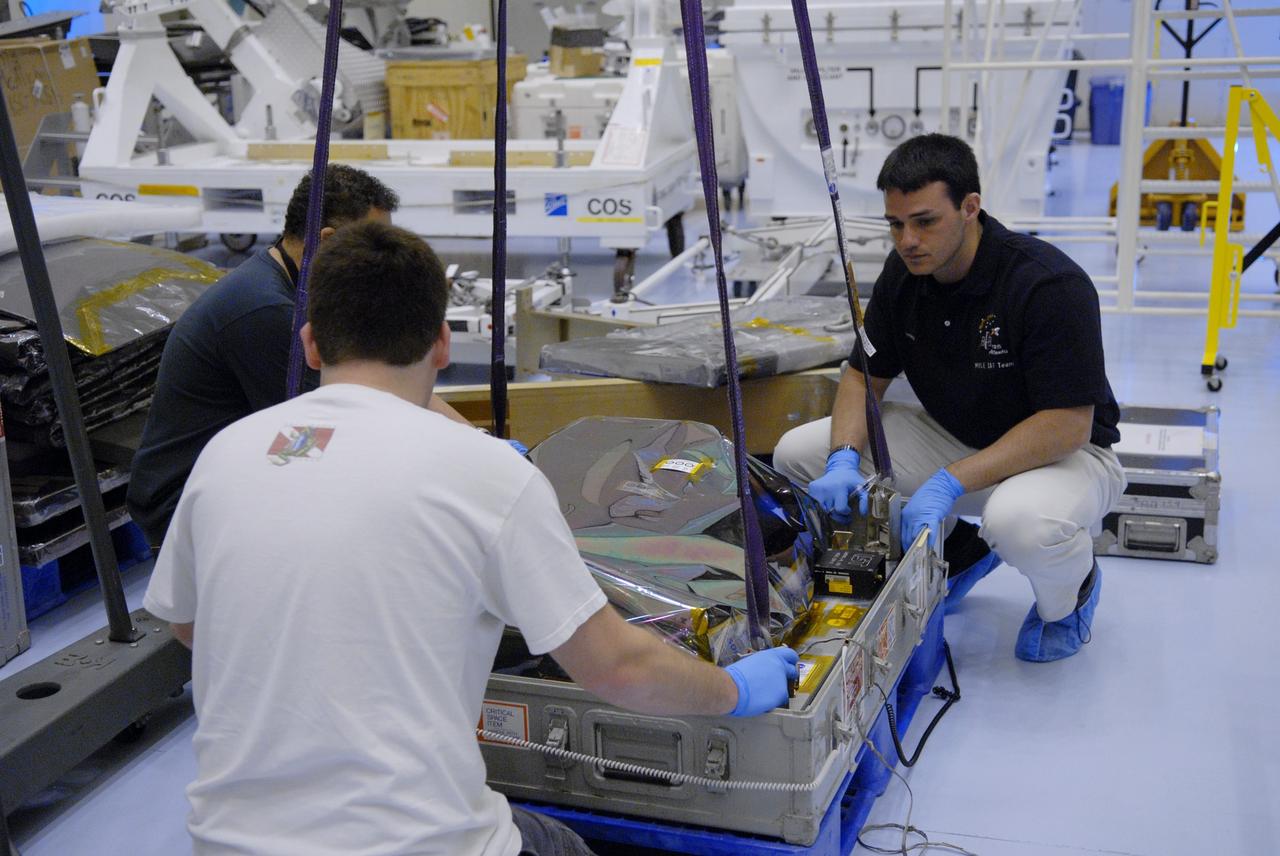 CAPE CANAVERAL, Fla. – In the Payload Hazardous Servicing Facility at NASA's Kennedy Space Center in Florida, technicians attach straps from a crane in order to lift the Science Instrument Command and Data Handling Unit, or SIC&DH. The SIC&DH will be installed on the Hubble Space Telescope during space shuttle Atlantis' STS-125 mission. This unit will replace the one that suffered a failure aboard the orbiting telescope on Sept. 27, 2008. The SIC&DH is being prepared for integration onto the Multi-Use Lightweight Equipment Carrier. The carrier holds the payload for space shuttle Atlantis' STS-125 mission servicing NASA's Hubble Space Telescope, targeted to launch May 12. Photo credit: NASA/Jack Pfaller