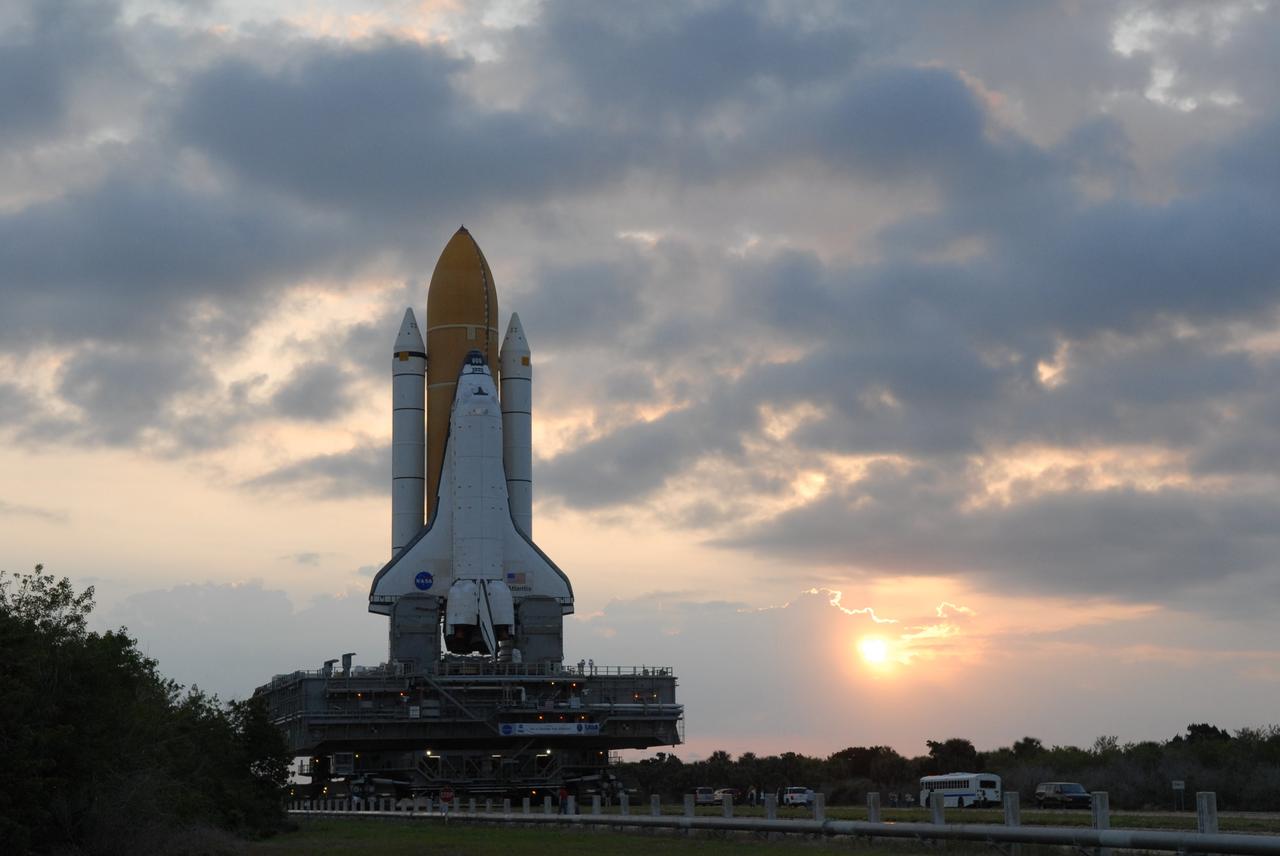 CAPE CANAVERAL, Fla. – After rollout from the Vehicle Assembly Building, clouds filter the morning sun as space shuttle Atlantis rolls out to Launch Pad 39A at NASA's Kennedy Space Center in Florida. The shuttle sits atop the mobile launcher platform, which is carried by the crawler-transporter beneath. First motion was at 3:54 a.m. EDT and Atlantis was secured on the pad at 11:17 a.m. The 3.4-mile trip took about seven-and-a-half hours. Atlantis is targeted to lift off May 12 to service NASA's Hubble Space Telescope. During Atlantis' 11-day mission, the crew of seven astronauts will make the final shuttle flight to Hubble. During five spacewalks, they will install two new instruments, repair two inactive ones and replace components. The result will be six working, complementary science instruments with capabilities beyond what is now available, and an extended operational lifespan for the telescope through at least 2014.   Photo credit: NASA/Jack Pfaller