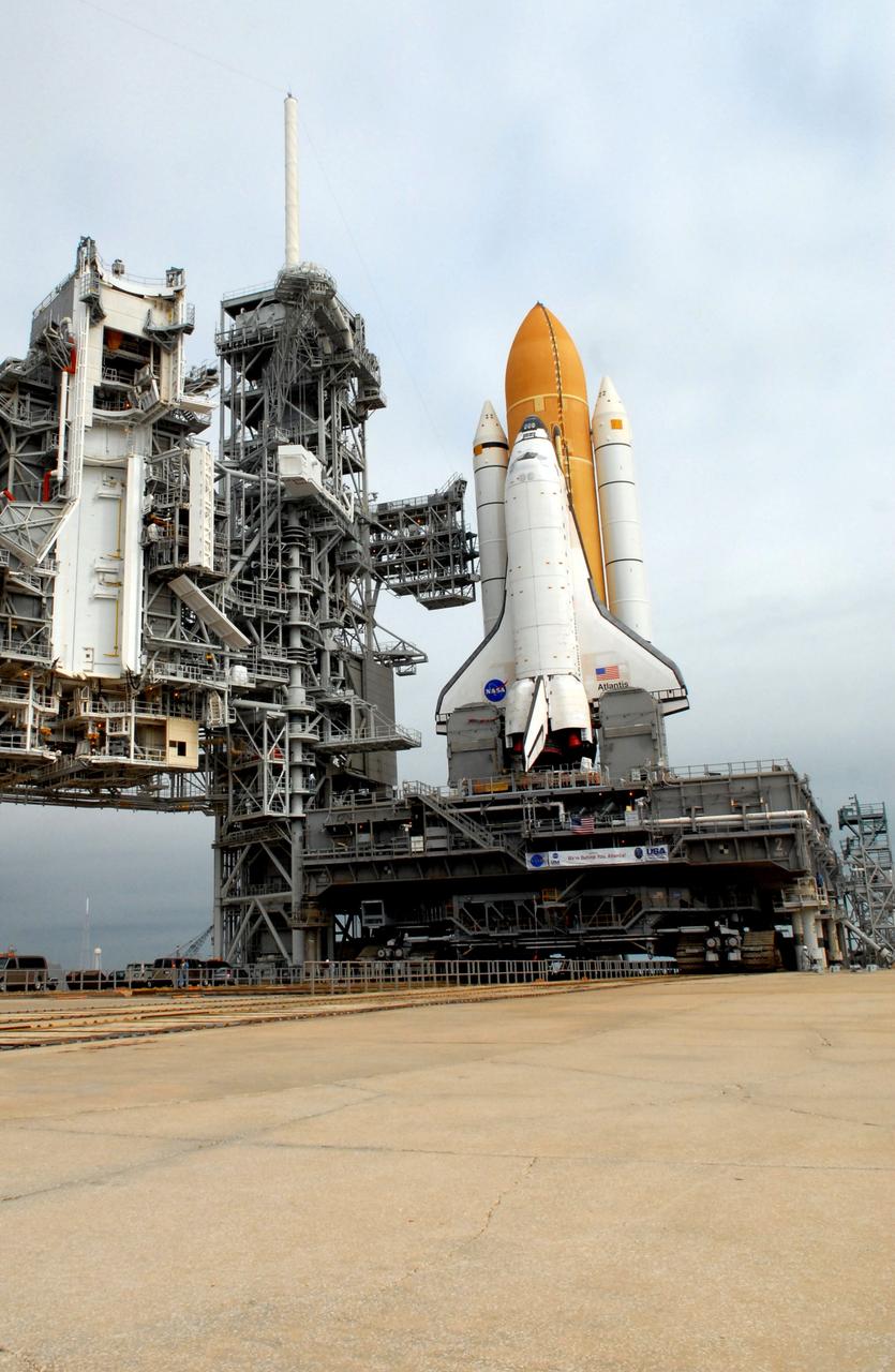 CAPE CANAVERAL, Fla. – Space shuttle Atlantis sits on Launch Pad 39A at NASA's Kennedy Space Center in Florida after rollout from the Vehicle Assembly Building. The shuttle sits atop the mobile launcher platform, which is carried by the crawler-transporter beneath. At left is the rotating service structure with the payload changeout room that allows transfer of payloads from a canister into the shuttle's payload bay. Next to the shuttle is the fixed service structure with its 80-foot lightning mast on top.  First motion was at 3:54 a.m. EDT and Atlantis was secured on the pad at 11:17 a.m. The 3.4-mile trip took about seven-and-a-half hours. Atlantis is targeted to lift off May 12 to service NASA's Hubble Space Telescope. During Atlantis' 11-day mission, the crew of seven astronauts will make the final shuttle flight to Hubble. During five spacewalks, they will install two new instruments, repair two inactive ones and replace components. The result will be six working, complementary science instruments with capabilities beyond what is now available, and an extended operational lifespan for the telescope through at least 2014.   Photo credit: NASA/Jack Pfaller