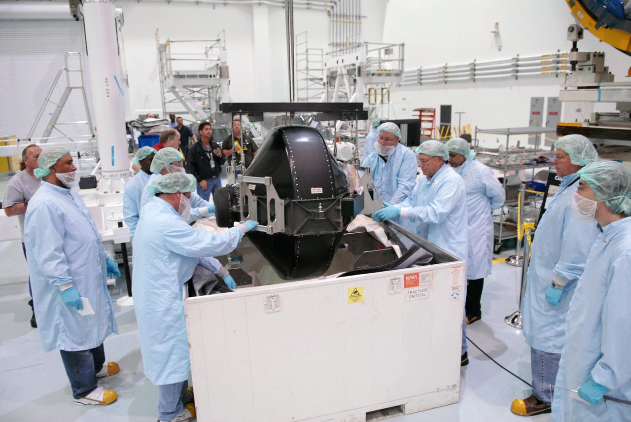 CAPE CANAVERAL, Fla. – In the Space Station Processing Facility at NASA's Kennedy Space Center in Florida, technicians oversee the removal of the control moment gyro, or CMG, from its container.  The CMG is part of the payload on the STS-129 mission to the International Space Station. On the mission, space shuttle Atlantis also will deliver the orbital spares and replacement parts to sustain the life of the station.  Photo credit: NASA/Troy Cryder