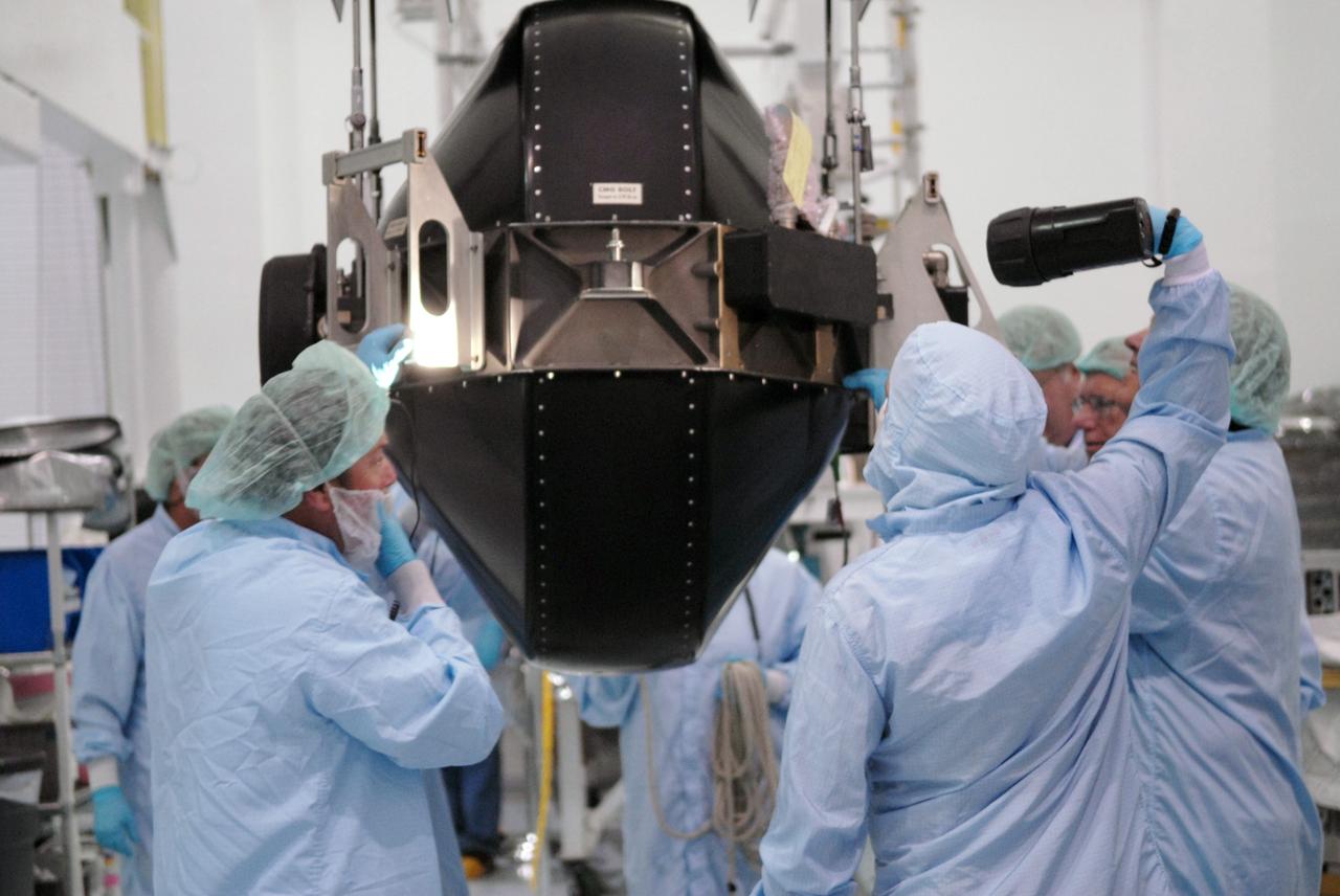 CAPE CANAVERAL, Fla. – In the Space Station Processing Facility at NASA's Kennedy Space Center in Florida, technicians using a light inspect the control moment gyroscope , or CMG, after removal from its container. The CMG  is suspended by a crane.  The CMG is part of the payload on the STS-129 mission to the International Space Station. On the mission, space shuttle Atlantis also will deliver the orbital spares and replacement parts to sustain the life of the station.  Photo credit: NASA/Troy Cryder