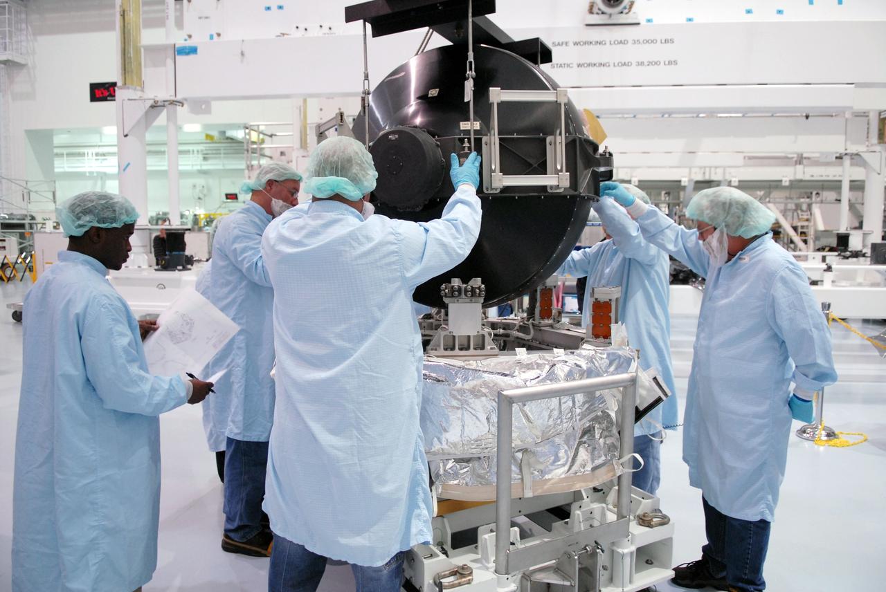 CAPE CANAVERAL, Fla. – In the Space Station Processing Facility at NASA's Kennedy Space Center in Florida, technicians help guide the control moment gyroscope, or CMG, onto the small adapter plate assembly. The CMG is part of the payload on the STS-129 mission to the International Space Station. On the mission, space shuttle Atlantis also will deliver the orbital spares and replacement parts to sustain the life of the station.  Photo credit: NASA/Troy Cryder