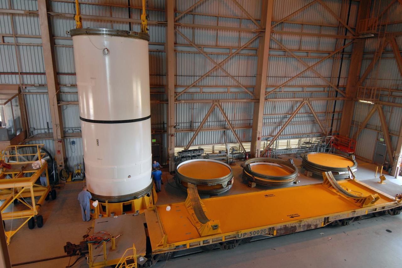 CAPE CANAVERAL, Fla. –  In the Rotation, Processing and Surge Facility at NASA's Kennedy Space Center in Florida, the Ares I-X center forward segment is secured onto a stand after the segment's removal from the transporter in the foreground. The booster used for the Ares I-X launch is being modified by adding new forward structures and a fifth segment simulator. The stacking operations are scheduled to begin in the Vehicle Assembly Building in April. Launch of the Ares I-X flight test is targeted for July 2009. Photo credit: NASA/Troy Cryder