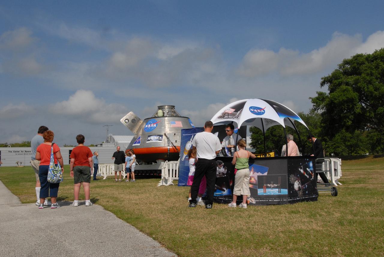 CAPE CANAVERAL, Fla. –  Visitors to the Visitor Complex at NASA's Kennedy Space Center in Florida get a look at the Orion crew exploration vehicle mockup, which is on display before heading offshore to be tested in open water.  The spacecraft mock-up traveled from the Naval Surface Warfare Center's Carderock Division in Bethesda, Md. The goal of the open water testing, dubbed the Post-landing Orion Recovery Test, or PORT, is to determine what kind of motion astronauts can expect after landing, as well as outside conditions for recovery teams. Part of the Constellation Program, Orion is targeted to begin carrying humans to the International Space Station in 2015 and to the moon by 2020.   Photo credit: NASA/Jack Pfaller