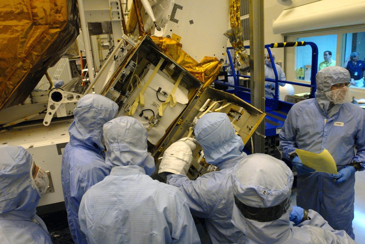 CAPE CANAVERAL, Fla. –  In the Payload Hazardous Servicing Facility at NASA's Kennedy Space Center in Florida, technicians look over the Science Instrument Command and Data Handling Unit, or SIC&DH, installed on the Multi-Use Lightweight Equipment Carrier.  The SIC&DH will be installed on the Hubble Space Telescope during space shuttle Atlantis' STS-125 mission. This unit will replace the one that suffered a failure aboard the orbiting telescope on Sept. 27, 2008. Atlantis is targeted for launch on May 12.  Photo credit: NASA/Dimitri Gerondidakis