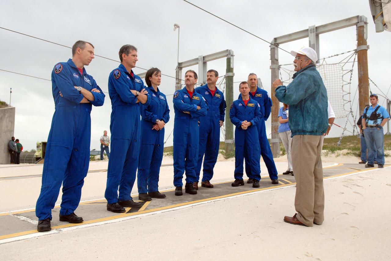 CAPE CANAVERAL, Fla. – In the slidewire basket landing area on Launch Pad 39A at NASA's Kennedy Space Center in Florida, STS-125 crew members listen to a trainer reviewing emergency exit procedures from the pad.  From left are Mission Specialists Andrew Feustel, Michael Good, Megan McArthur and John Grunsfeld, Commander Scott Altman, Pilot Gregory C. Johnson and Mission Specialist Mike Massimino.   Space shuttle Atlantis' 11-day flight is targeted for launch May 12 and will include five spacewalks to refurbish and upgrade the telescope with state-of-the-art science instruments. As a result, Hubble's capabilities will be expanded and its operational lifespan extended through at least 2014.  Photo credit: NASA/Cory Huston