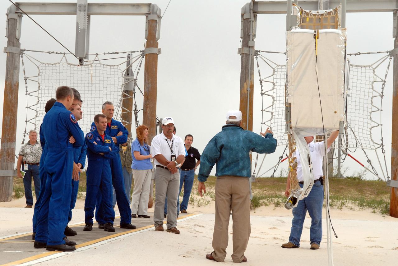 CAPE CANAVERAL, Fla. – In the slidewire basket landing area on Launch Pad 39A at NASA's Kennedy Space Center in Florida, STS-125 crew members review exit techniques from the basket used for emergency exit from the pad. Visible from left are Mission Specialist Andrew Feustel, Commander Scott Altman, Mission Specialist John Grunsfeld, Pilot Gregory C. Johnson and Mission Specialist Mike Massimino. Space shuttle Atlantis' 11-day flight is targeted for launch May 12 and will include five spacewalks to refurbish and upgrade the telescope with state-of-the-art science instruments. As a result, Hubble's capabilities will be expanded and its operational lifespan extended through at least 2014.  Photo credit: NASA/Cory Huston