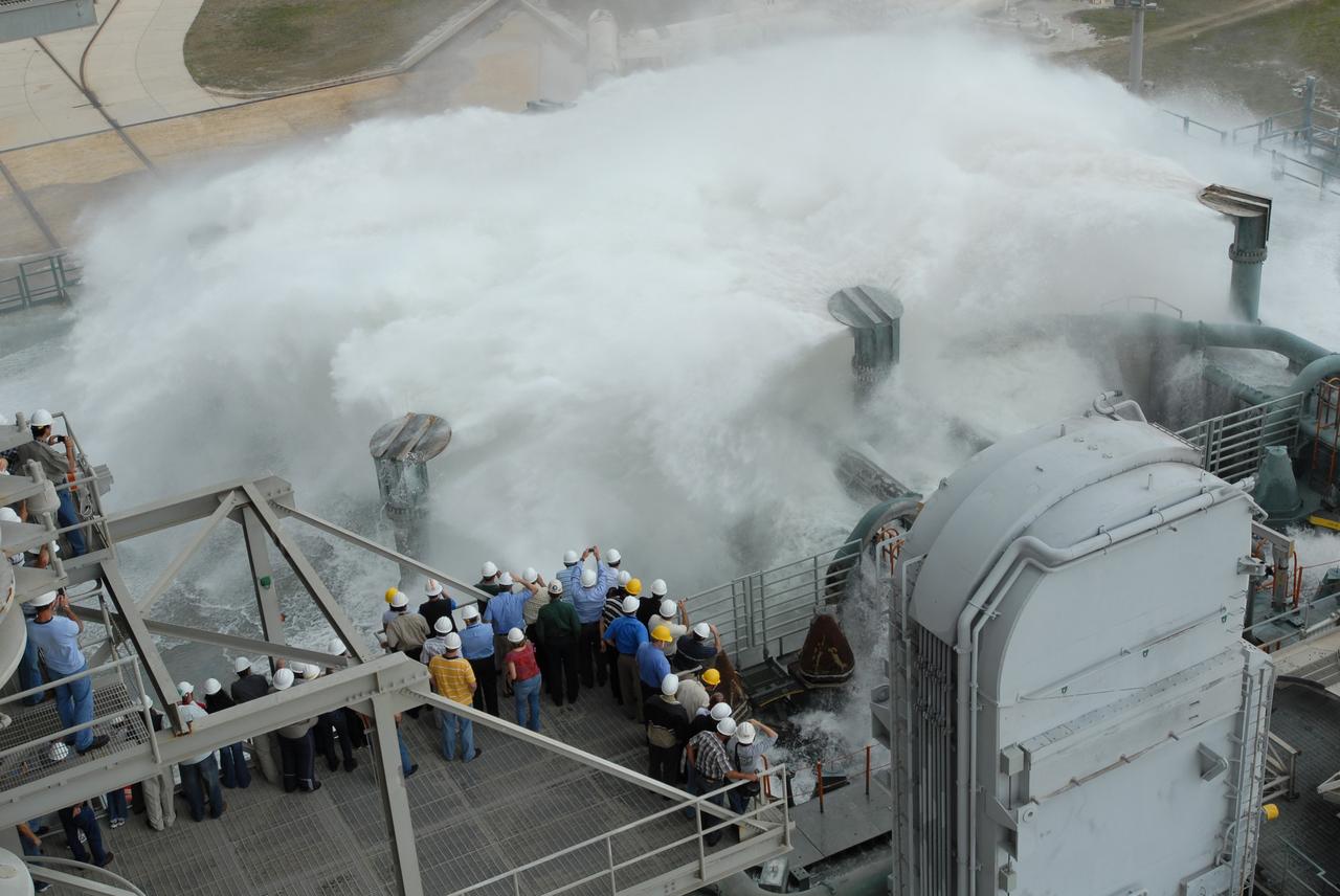 CAPE CANAVERAL, Fla. – The sound suppression system is tested on the mobile launcher platform on Launch Pad 39B at NASA's Kennedy Space Center in Florida. Pad 39B will be the site of the first Ares vehicle launch, including the Ares I-X flight test that is targeted for summer 2009. The mobile launcher platform was handed over to the Constellation Program and modified for the Ares I-X flight test. It is being tested before being moved to the Vehicle Assembly Building for assembly of the Ares I-X rocket. A sound suppression water system is in¬stalled on the pads to protect against damage by acoustical energy and rocket exhaust reflected from the flame trench and mobile launcher plat¬form during a launch. The sound suppression system includes an elevated 290-foot-high water tank with a capacity of 300,000 gallons. The water releases just prior to the ignition of the rocket and flows through 7-foot-diameter pipes for about 20 seconds. A torrent of water will flow onto the mobile launcher platform from six large quench nozzles, or “rainbirds,” mounted on its surface. The rainbirds are 12 feet high. The two in the center are 42 inches in diameter; the other four have a 30-inch diameter. Photo credit: NASA/Jim Grossmann