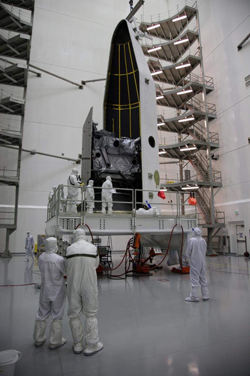 CAPE CANAVERAL, Fla. – In the Astrotech payload processing facility in Titusville, Fla., the first half of the payload fairing is moved around the GOES-O satellite. The fairing is a molded structure that fits flush with the outside surface of the rocket and forms an aerodynamically smooth nose cone, protecting the spacecraft during launch and ascent. The latest Geostationary Operational Environmental Satellite, GOES-O was developed by NASA for the National Oceanic and Atmospheric Administration, or NOAA. The GOES satellites continuously provide observations of 60 percent of the Earth including the continental United States, providing weather monitoring and forecast operations as well as a continuous and reliable stream of environmental information and severe weather warnings. Once in orbit, GOES-O will be designated GOES-14, and NASA will provide on-orbit checkout and then transfer operational responsibility to NOAA. The GOES-O satellite is targeted to launch from Cape Canaveral Air Force Station's Launch Complex 37 on April 28 onboard a United Launch Alliance Delta IV expendable launch vehicle. Photo credit: NASA/Dimitri Gerondidakis