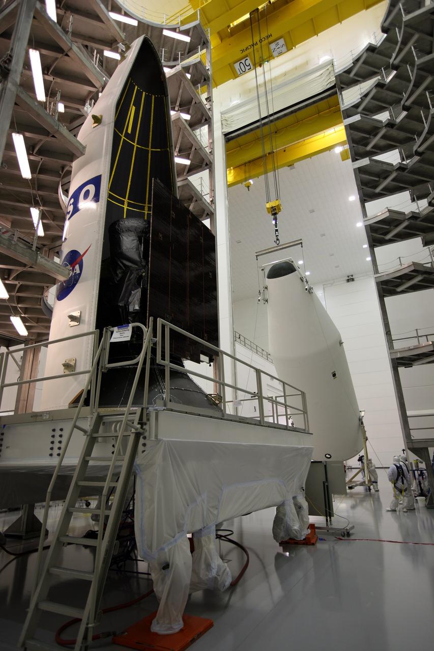CAPE CANAVERAL, Fla. – In the Astrotech payload processing facility in Titusville, Fla., the first half of the payload fairing has been placed around the GOES-O satellite, at left. In the background, the second half is being lifted to vertical for its placement around GOES-O. The fairing is a molded structure that fits flush with the outside surface of the rocket and forms an aerodynamically smooth nose cone, protecting the spacecraft during launch and ascent. The latest Geostationary Operational Environmental Satellite, GOES-O was developed by NASA for the National Oceanic and Atmospheric Administration, or NOAA. The GOES satellites continuously provide observations of 60 percent of the Earth including the continental United States, providing weather monitoring and forecast operations as well as a continuous and reliable stream of environmental information and severe weather warnings. Once in orbit, GOES-O will be designated GOES-14, and NASA will provide on-orbit checkout and then transfer operational responsibility to NOAA. The GOES-O satellite is targeted to launch from Cape Canaveral Air Force Station's Launch Complex 37 on April 28 onboard a United Launch Alliance Delta IV expendable launch vehicle. Photo credit: NASA/Dimitri Gerondidakis