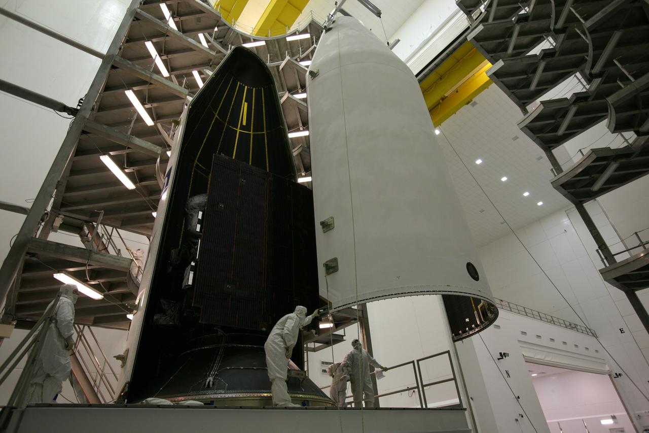 CAPE CANAVERAL, Fla. – In the Astrotech payload processing facility in Titusville, Fla., technicians monitor the second half of the payload fairing as it is moved toward the GOES-O satellite to complete encapsulation. The fairing is a molded structure that fits flush with the outside surface of the rocket and forms an aerodynamically smooth nose cone, protecting the spacecraft during launch and ascent. The latest Geostationary Operational Environmental Satellite, GOES-O was developed by NASA for the National Oceanic and Atmospheric Administration, or NOAA. The GOES satellites continuously provide observations of 60 percent of the Earth including the continental United States, providing weather monitoring and forecast operations as well as a continuous and reliable stream of environmental information and severe weather warnings. Once in orbit, GOES-O will be designated GOES-14, and NASA will provide on-orbit checkout and then transfer operational responsibility to NOAA. The GOES-O satellite is targeted to launch from Cape Canaveral Air Force Station's Launch Complex 37 on April 28 onboard a United Launch Alliance Delta IV expendable launch vehicle. Photo credit: NASA/Dimitri Gerondidakis
