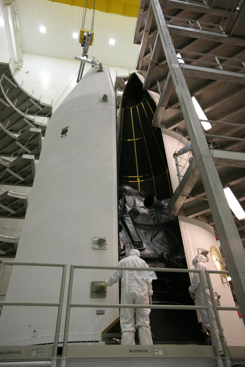 CAPE CANAVERAL, Fla. – In the Astrotech payload processing facility in Titusville, Fla., technicians monitor the second half of the payload fairing as it is moved closer to the GOES-O satellite to complete encapsulation. The fairing is a molded structure that fits flush with the outside surface of the rocket and forms an aerodynamically smooth nose cone, protecting the spacecraft during launch and ascent. The latest Geostationary Operational Environmental Satellite, GOES-O was developed by NASA for the National Oceanic and Atmospheric Administration, or NOAA. The GOES satellites continuously provide observations of 60 percent of the Earth including the continental United States, providing weather monitoring and forecast operations as well as a continuous and reliable stream of environmental information and severe weather warnings. Once in orbit, GOES-O will be designated GOES-14, and NASA will provide on-orbit checkout and then transfer operational responsibility to NOAA. The GOES-O satellite is targeted to launch from Cape Canaveral Air Force Station's Launch Complex 37 on April 28 onboard a United Launch Alliance Delta IV expendable launch vehicle. Photo credit: NASA/Dimitri Gerondidakis