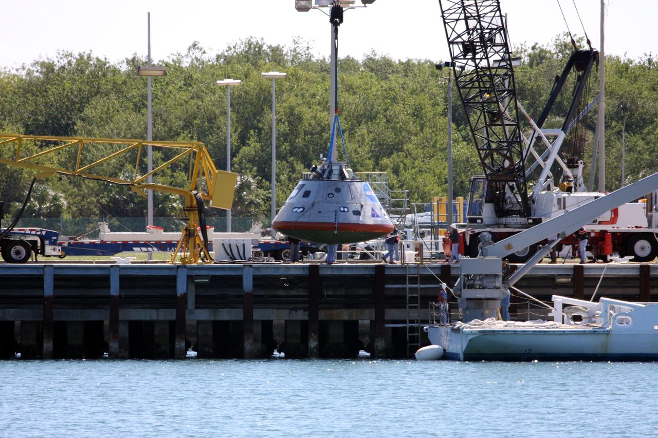 CAPE CANAVERAL, Fla. – The mockup Orion crew exploration vehicle is lowered toward the water at the Trident Basin at Port Canaveral, Fla., for testing. Orion is targeted to begin carrying humans to the International Space Station in 2015 and to the moon by 2020. The goal of the operation, dubbed the Post-landing Orion Recovery Test, or PORT, is to determine what kind of motion astronauts can expect after landing, as well as outside conditions for recovery teams.  Orion, along with the Ares I and V rockets and the Altair lunar lander, are part of the Constellation Program.  Photo credit: NASA/Dimitri Gerondidakis