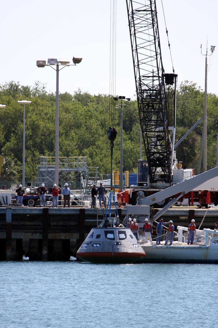 CAPE CANAVERAL, Fla. – The mockup Orion crew exploration vehicle is lowered into the water at the Trident Basin at Port Canaveral, Fla., for testing. Orion is targeted to begin carrying humans to the International Space Station in 2015 and to the moon by 2020. The goal of the operation, dubbed the Post-landing Orion Recovery Test, or PORT, is to determine what kind of motion astronauts can expect after landing, as well as outside conditions for recovery teams.  Orion, along with the Ares I and V rockets and the Altair lunar lander, are part of the Constellation Program.  Photo credit: NASA/Dimitri Gerondidakis