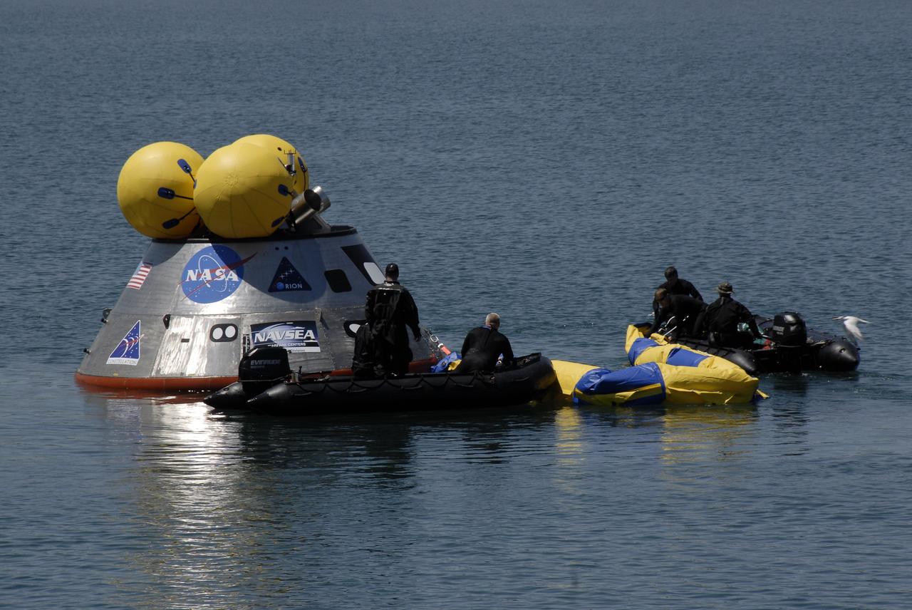 CAPE CANAVERAL, Fla. – Members of the 920th Rescue Wing release a flotation collar around the mockup Orion crew exploration vehicle at the Trident Basin at Port Canaveral, Fla.  On top of Orion are additional flotation devices. The mockup vehicle will undergo testing in open water. The goal of the operation, dubbed the Post-landing Orion Recovery Test, or PORT, is to determine what kind of motion astronauts can expect after landing, as well as outside conditions for recovery teams.  Orion is targeted to begin carrying humans to the International Space Station in 2015 and to the moon by 2020. Orion, along with the Ares I and V rockets and the Altair lunar lander, are part of the Constellation Program.  Photo credit: NASA/Kim Shiflett