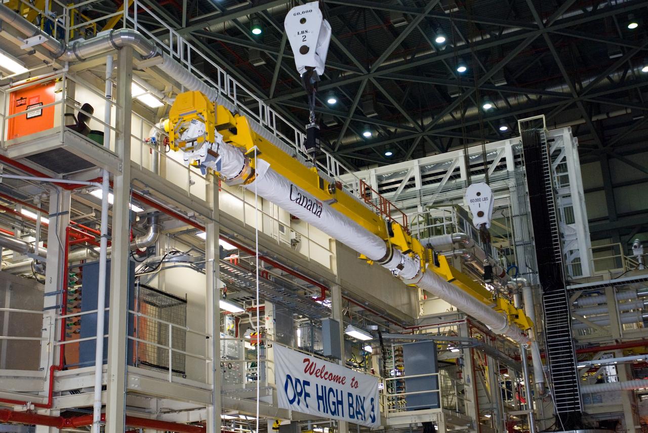 CAPE CANAVERAL, Fla. – In the Orbiter Processing Facility’s bay 3, the orbiter boom sensor system is lifted by a crane for installation in space shuttle Discovery’s payload bay for mission STS-128. The 50-foot-long boom attaches to the shuttle arm and provides equipment to inspect the shuttle's heat shield while in space. It contains an intensified television camera (ITVC) and a laser dynamic range imager, which are mounted on a pan and tilt unit, and a laser camera system (LCS) mounted on a stationary bracket.  The STS-128 flight will carry science and storage racks to the International Space Station on space shuttle Discovery. Launch of Discovery is targeted for Aug. 6. Photo credit: NASA/Jim Grossmann