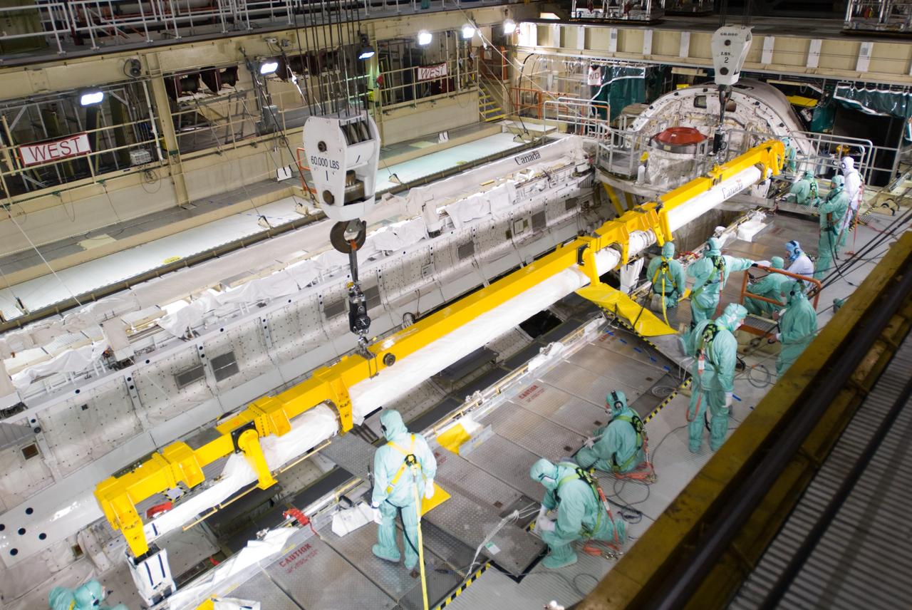 CAPE CANAVERAL, Fla. – In the Orbiter Processing Facility’s bay 3, workers prepare to install the orbiter boom sensor system in the payload bay of space shuttle Discovery to support mission STS-128.  The 50-foot-long boom attaches to the shuttle arm and provides equipment to inspect the shuttle's heat shield while in space. It contains an intensified television camera (ITVC) and a laser dynamic range imager, which are mounted on a pan and tilt unit, and a laser camera system (LCS) mounted on a stationary bracket.  The STS-128 flight will carry science and storage racks to the International Space Station on space shuttle Discovery. Launch of Discovery is targeted for Aug. 6. Photo credit: NASA/Jim Grossmann