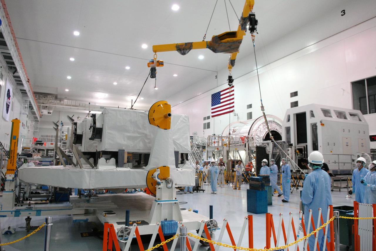 CAPE CANAVERAL, Fla. – In the Space Station Processing Facility at NASA's Kennedy Space Center in Florida,  workers maneuver a crane that will be attached to the Kibo Experiment Logistics Module Exposed Section, or ELM-ES, at left.  The ELM-ES will be moved to a workstand. The ELM-ES is one of the final components of the Japan Aerospace Exploration Agency's Kibo laboratory for the International Space Station.  It can provide payload storage space and can carry up to three payloads at launch. The ELM-ES will be carried aboard space shuttle Endeavour on the STS-127 mission targeted for launch Aug. 6.  Photo credit: NASA/Jack Pfaller