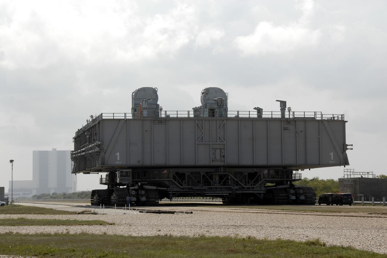 CAPE CANAVERAL, Fla. – At NASA's Kennedy Space Center in Florida, the mobile launcher platform that was turned over from the shuttle program to the Constellation Program last month moves along the crawlerway via the crawler-transporter underneath. In the background is the Vehicle Assembly Building. The platform will be rolled into the VAB's High Bay 3 in preparation for the Ares I-X flight test this summer.  Ares I-X is the test vehicle for the Ares I, which is part of the Constellation Program to return men to the moon and beyond.  Ground Control System hardware was installed in MLP-1 in December 2008.  The platform was moved to the launch pad to check out the installed hardware with the Launch Control Center Firing Room 1 equipment, using the actual circuits that will be used when the fully stacked Ares I-X vehicle is rolled out later this year for launch.  Photo credit: NASA/Kim Shiflett