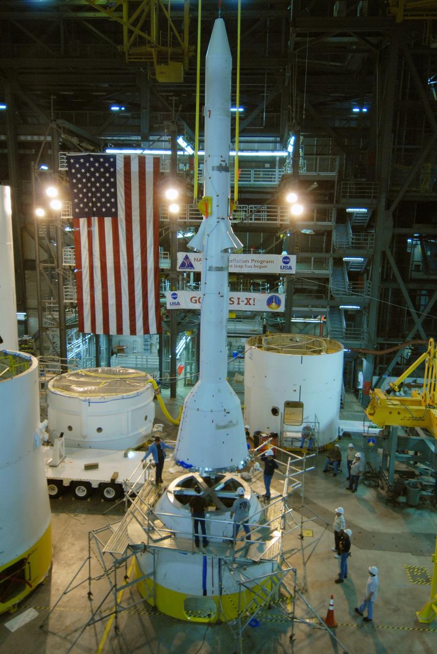 CAPE CANAVERAL, Fla. – In high bay 4 of the Vehicle Assembly Building at NASA's Kennedy Space Center in Florida, workers keep close watch on the Ares I-X simulated launch abort system, or LAS, as it is lowered toward the crew module simulator.  Ares I-X is the flight test vehicle for the Ares I, which is part of the Constellation Program to return men to the moon and beyond. Ares I is the essential core of a safe, reliable, cost-effective space transportation system that eventually will carry crewed missions back to the moon, on to Mars and out into the solar system. Ares I-X is targeted for launch in July 2009. Photo credit: NASA/Jack Pfaller