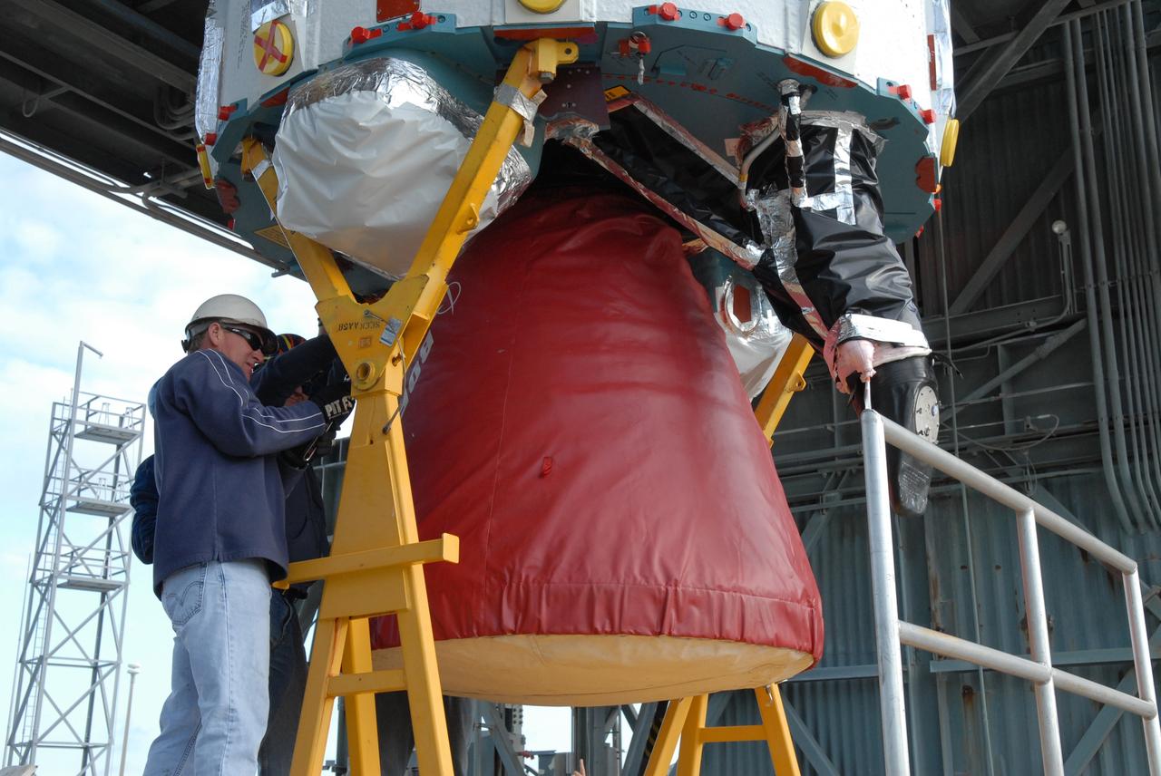 CAPE CANAVERAL, Fla. – On Cape Canaveral Air Force Station's Launch Complex 17-B in Florida, workers check the first stage of a Delta II rocket before it is lifted into the mobile service tower.  The rocket is the launch vehicle for the STSS Demonstrators Program. STSS Demonstrators Program is a midcourse tracking technology demonstrator and is part of an evolving ballistic missile defense system. STSS is capable of tracking objects after boost phase and provides trajectory information to other sensors. It will be launched by NASA for the Missile Defense Agency on July 29.  Photo credit: NASA/Jack Pfaller