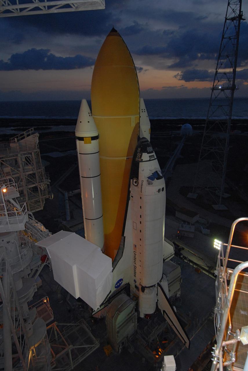 CAPE CANAVERAL, Fla. – Just before dawn, space shuttle Endeavour, installed on the mobile launcher platform  atop the crawler-transporter, is on Launch Pad 39B at NASA's Kennedy Space Center in Florida.  First motion out of the Vehicle Assembly Building was at 11:57 p.m. EDT April 16.  The shuttle was secure on the pad at 7:17 a.m. EDT April 17. On the left of the shuttle is the White Room at the end of the orbiter access arm, 147 feet above the pad. When in place against the shuttle, the White Room provides access into the crew compartment on the shuttle. Endeavour will be prepared on the pad for liftoff in the unlikely event that a rescue mission is necessary following space shuttle Atlantis' launch on the STS-125 mission to service NASA's  Hubble Space Telescope. After Atlantis is cleared to land, Endeavour will move to Launch Pad 39A for its upcoming STS-127 mission to the International Space Station, targeted to launch June 13.   Photo credit: NASA/Jack Pfaller