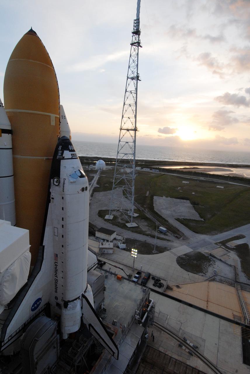 CAPE CANAVERAL, Fla. – The rising sun begins to cast its glow over space shuttle Endeavour on Launch Pad 39B at NASA's Kennedy Space Center in Florida. Behind the shuttle is the new lightning tower erected for NASA's Constellation Program, which will use the pad for Ares rocket launches. First motion of Endeavour's rollout from the Vehicle Assembly Building was at 11:57 p.m. EDT April 16. Endeavour will be prepared on the pad for liftoff in the unlikely event that a rescue mission is necessary following space shuttle Atlantis' launch on the STS-125 mission to service NASA's Hubble Space Telescope. After Atlantis is cleared to land, Endeavour will move to Launch Pad 39A for its upcoming STS-127 mission to the International Space Station, targeted to launch June 13. Photo credit: NASA/Jack Pfaller