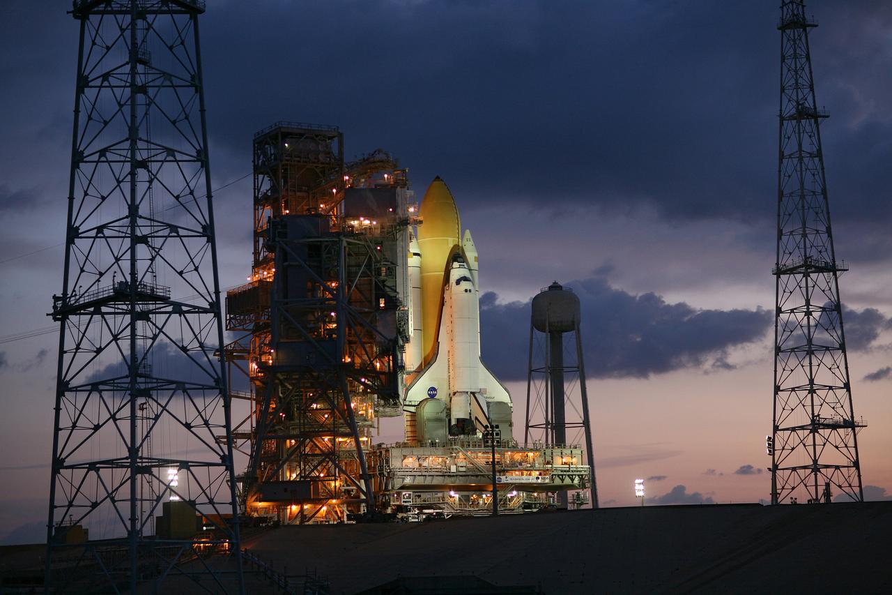 CAPE CANAVERAL, Fla. – Just before dawn, space shuttle Endeavour is bathed in xenon lights after being  secured on Launch Pad 39B at NASA's Kennedy Space Center in Florida.  First motion on rollout from the Vehicle Assembly Building was at 11:57 p.m. EDT April 16.  On either side of the pad are two of the new lightning towers erected for NASA's Constellation Program, which will use the pad for Ares rocket launches.  Endeavour will be prepared on the pad for liftoff in the unlikely event that a rescue mission is necessary following space shuttle Atlantis' launch on the STS-125 mission to service NASA's  Hubble Space Telescope. After Atlantis is cleared to land, Endeavour will move to Launch Pad 39A for its upcoming STS-127 mission to the International Space Station, targeted to launch June 13.  Photo credit: NASA/Dimitri Gerondidakis