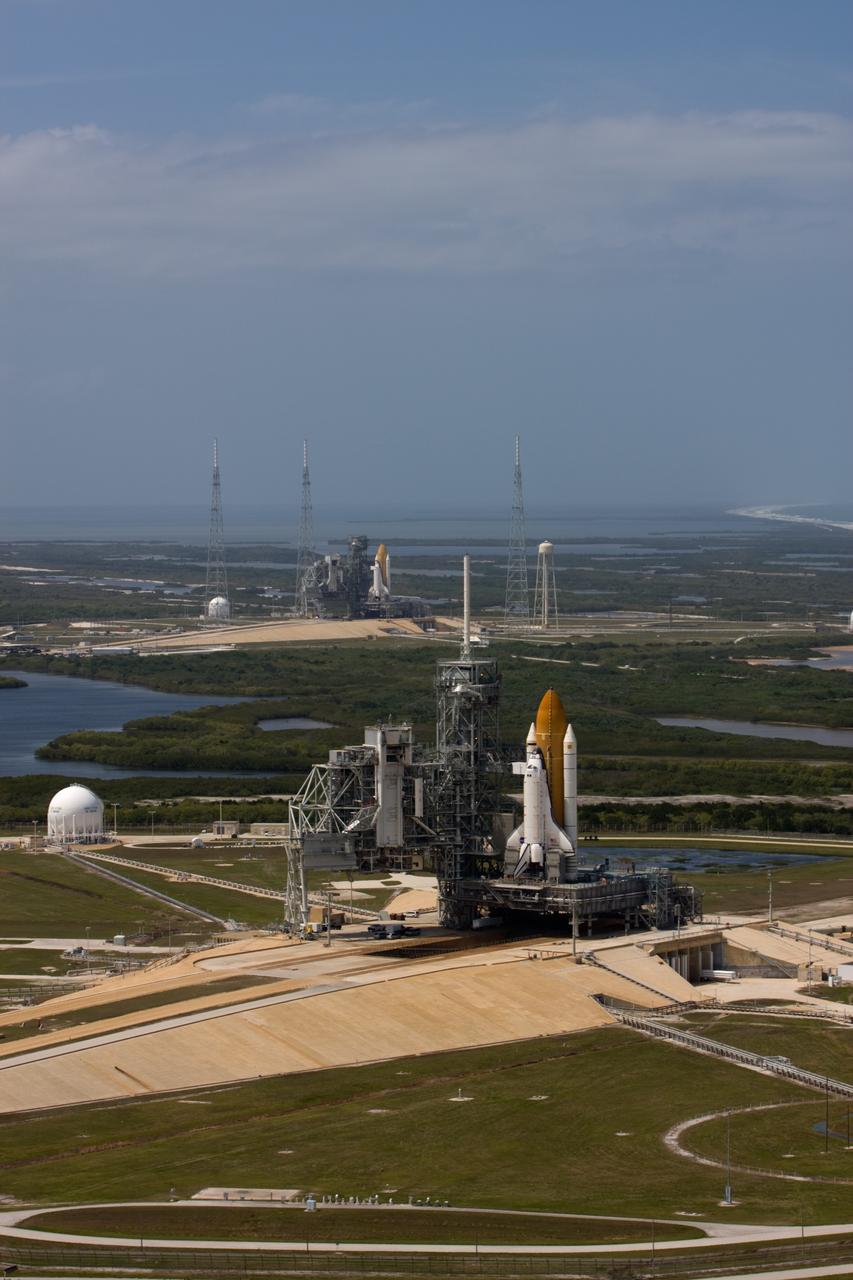CAPE CANAVERAL, Fla. – After space shuttle Endeavour's rollout to Launch pad 39B at NASA's Kennedy Space Center in Florida this morning, two different shuttles are poised on two different launch pads. Shuttle Atlantis (foreground) already was on Launch Pad 39A. With the space shuttle fleet set for retirement in 2010, this is expected to be the final time two shuttles will be on launch pads at the same time. Endeavour will stand by at pad B in the unlikely event that a rescue mission is necessary during Atlantis' upcoming mission to upgrade NASA's Hubble Space Telescope. Atlantis is targeted to launch May 12. After Endeavour is cleared from its duty as a rescue spacecraft, it will be moved to Launch Pad 39A for its STS-127 mission to the International Space Station. That flight is targeted for launch June 13. Photo credit: NASA/Dimitri Gerondidakis