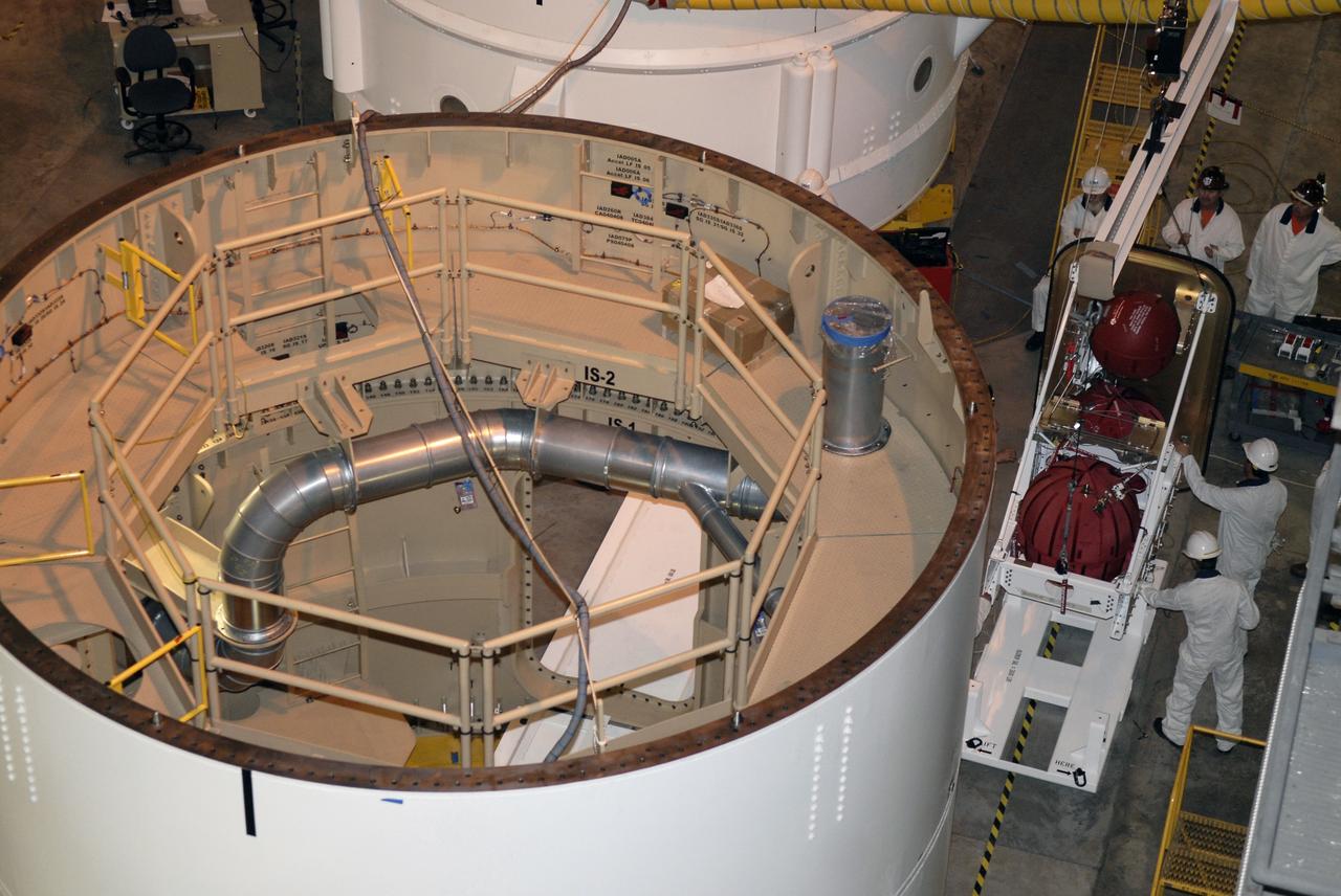 CAPE CANAVERAL, Fla. – In high bay 4 of the Vehicle Assembly Building at NASA's Kennedy Space Center in Florida, at right, technicians get ready to install the roll control system in the Ares I-X segment at left.  Ares I-X is the test vehicle for the Ares I, which is part of the Constellation Program to return men to the moon and beyond. Ares I-X is targeted for launch in July 2009.  Photo credit: NASA/Kim Shiflett