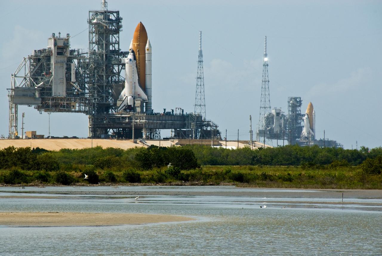 CAPE CANAVERAL, Fla. –– Viewed from the shoreline at NASA's Kennedy Space Center in Florida, space shuttles Atlantis (left) and Endeavour (right) are seen on Launch Pad 39A and 39B respectively. With the space shuttle fleet set for retirement in 2010, this is expected to be the final time two shuttles will be on launch pads at the same time.  Endeavour will stand by at pad B in the unlikely event that a rescue mission is necessary during Atlantis' upcoming mission to upgrade NASA's Hubble Space Telescope. Atlantis is targeted to launch May 12. After Endeavour is cleared from its duty as a rescue spacecraft, it will be moved to Launch Pad 39A for its STS-127 mission to the International Space Station. That flight is targeted for launch June 13.   Photo credit:  NASA/Kim Shiflett