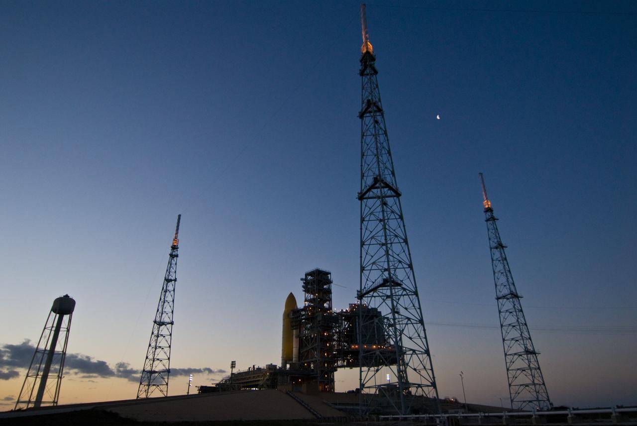CAPE CANAVERAL, Fla. –– Space shuttle Endeavour is silhouetted against the dawn pink sky on Launch Pad 39B at NASA's Kennedy Space Center in Florida.  Surrounding the pad are the lightning towers erected for NASA's Constellation Program, which will use the pad for Ares rocket launches.  Dotting the dark blue sky at upper right is the moon. Endeavour will be prepared on the pad for liftoff in the unlikely event that a rescue mission is necessary following space shuttle Atlantis' launch May 12 on the STS-125 mission to upgrade NASA's Hubble Space Telescope. After Atlantis is cleared to land, Endeavour will move to Launch Pad 39A for its upcoming STS-127 mission to the International Space Station, targeted to launch June 13. Photo credit: NASA/Jack Pfaller