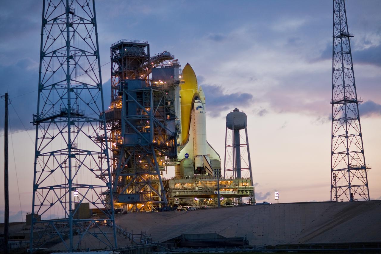 CAPE CANAVERAL, Fla. –– As dawn begins to brighten the sky over Launch Pad 39B at NASA's Kennedy Space Center in Florida, space shuttle Endeavour is seen bathed in lights from the fixed service structure. Endeavour  joins Atlantis, which is on Launch Pad 39A. The towers around the launch pad were erected for NASA's Constellation Program, which will use the pad for Ares rocket launches.  With the space shuttle fleet set for retirement in 2010, this is expected to be the final time two shuttles will be on launch pads at the same time.  Endeavour will be prepared on the pad for liftoff in the unlikely event that a rescue mission is necessary following space shuttle Atlantis' launch on the STS-125 mission to service NASA's  Hubble Space Telescope. After Atlantis is cleared to land, Endeavour will move to Launch Pad 39A for its upcoming STS-127 mission to the International Space Station, targeted to launch June 13.  Photo credit: NASA/Dimitri Gerondidakis