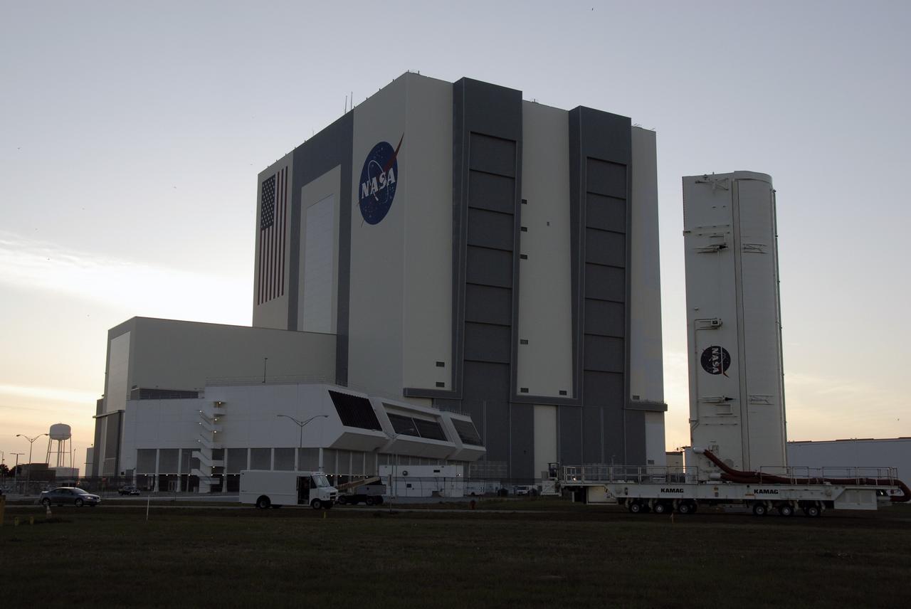 CAPE CANAVERAL, Fla. –– At NASA's Kennedy Space Center in Florida, the payload canister with the Hubble Space Telescope equipment passes the Vehicle Assembly Building and Launch Control Center (left) as it heads for Launch Pad 39A.  On the pad, the Hubble equipment will be transferred to space shuttle Atlantis' payload bay. Atlantis' 11-day STS-125 mission to service Hubble is targeted for launch May 12.  The flight will include five spacewalks in which astronauts will refurbish and upgrade the telescope with state-of-the-art science instruments. As a result, Hubble's capabilities will be expanded and its operational lifespan extended through at least 2014.  Photo credit: NASA/Kim Shiflett